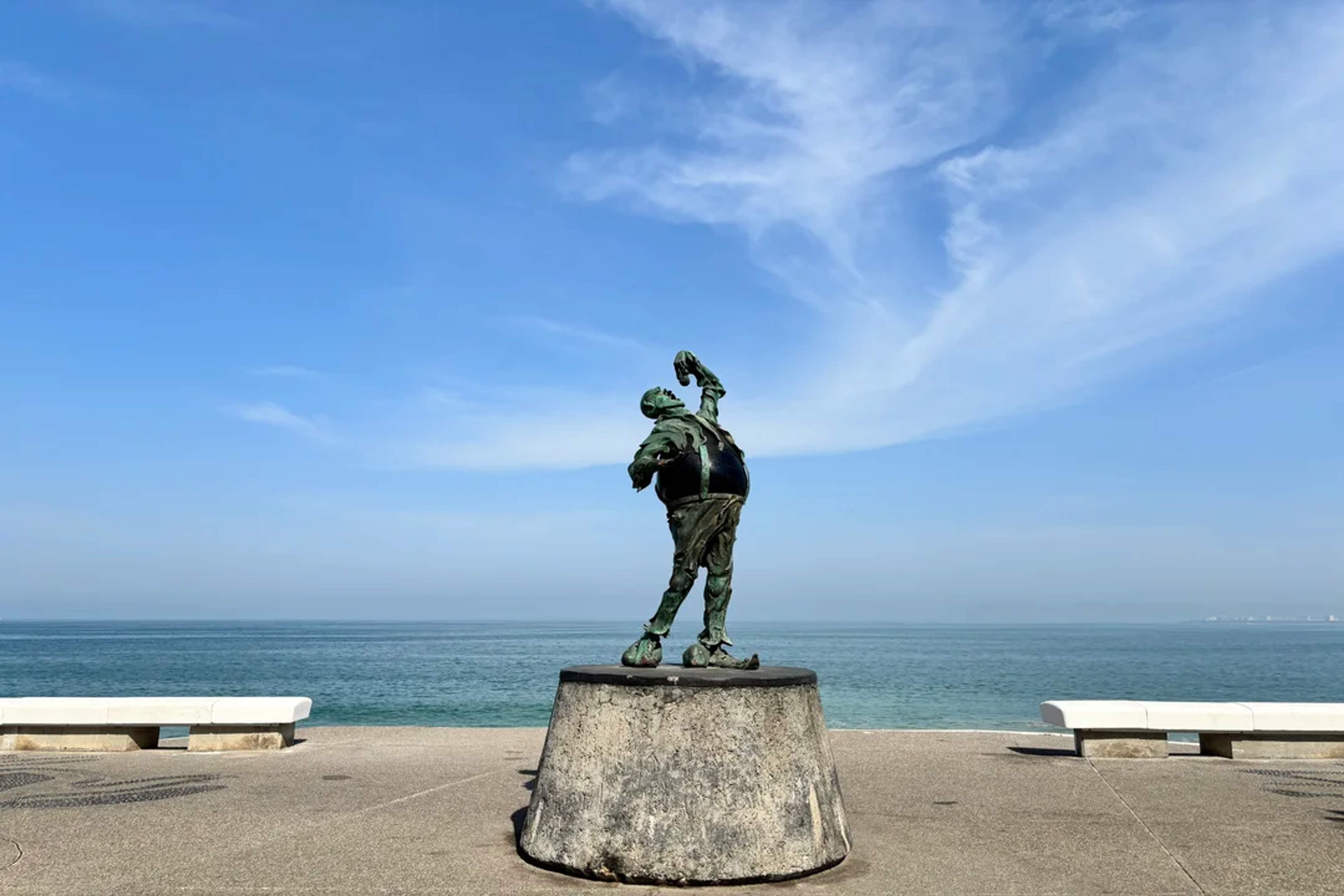 Iconic sculpture on the Puerto Vallarta Malecón with ocean views and a clear blue sky.