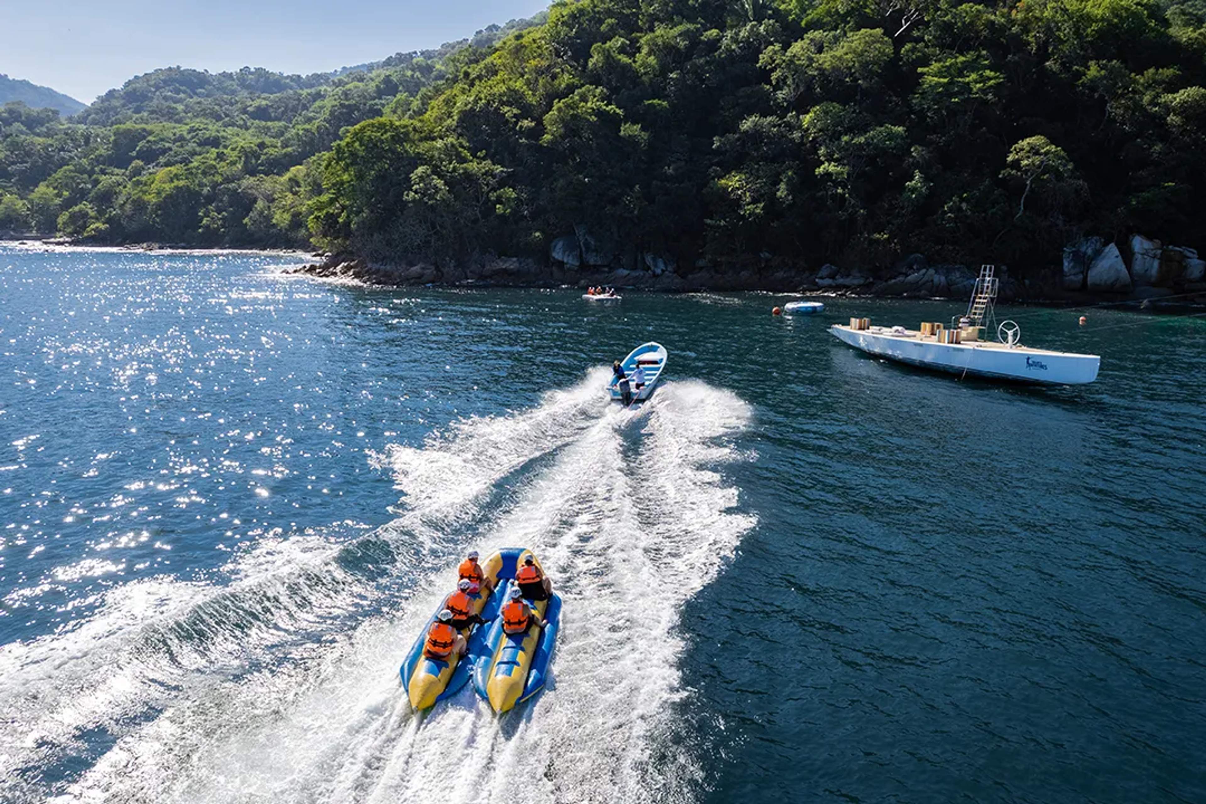 Banana boats riding through a tropical cove in Puerto Vallarta during the fun Ocean Mania adventure tour
