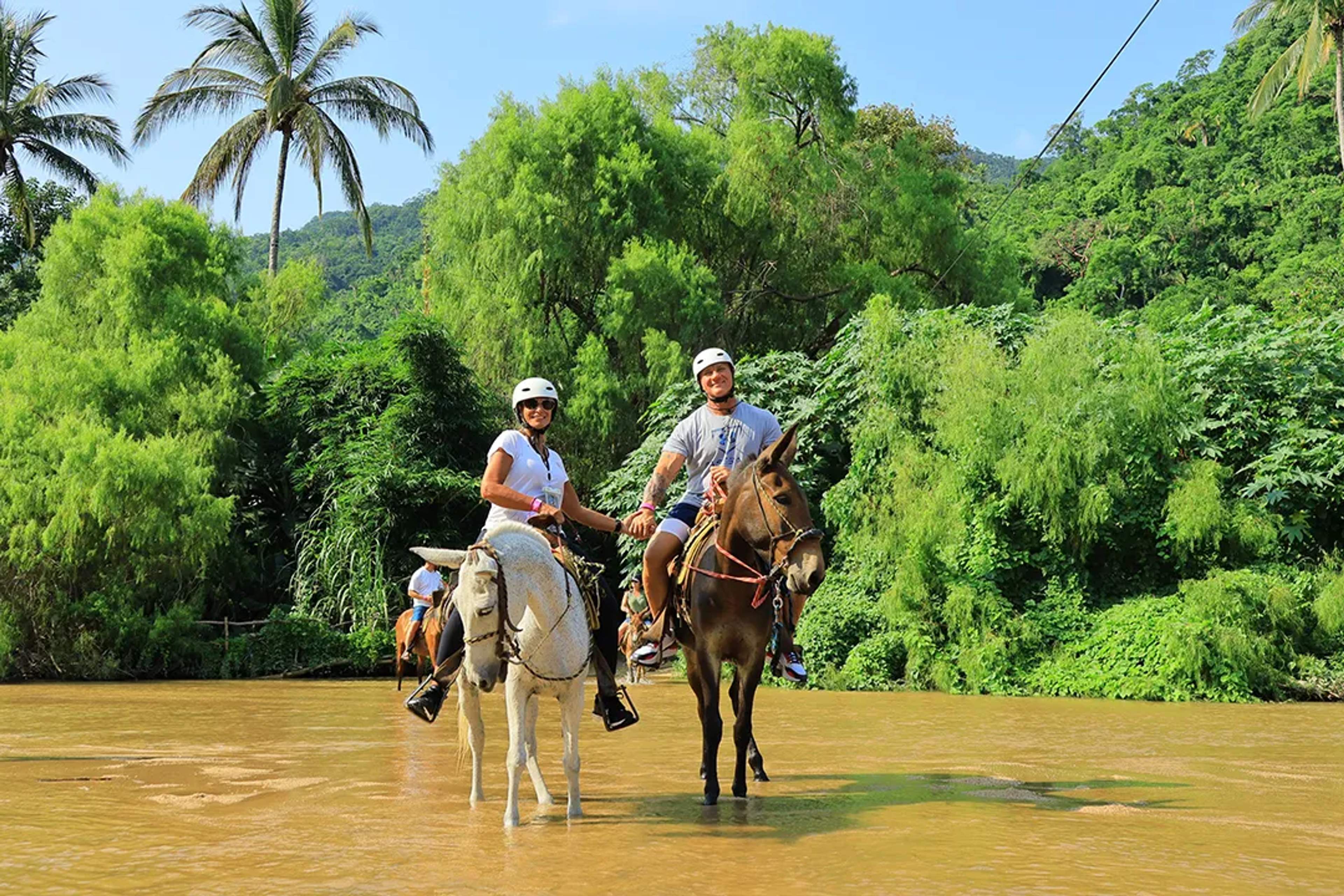 Tour a caballo en la selva de Puerto Vallarta — parejas disfrutando una aventura cruzando ríos y senderos tropicales.