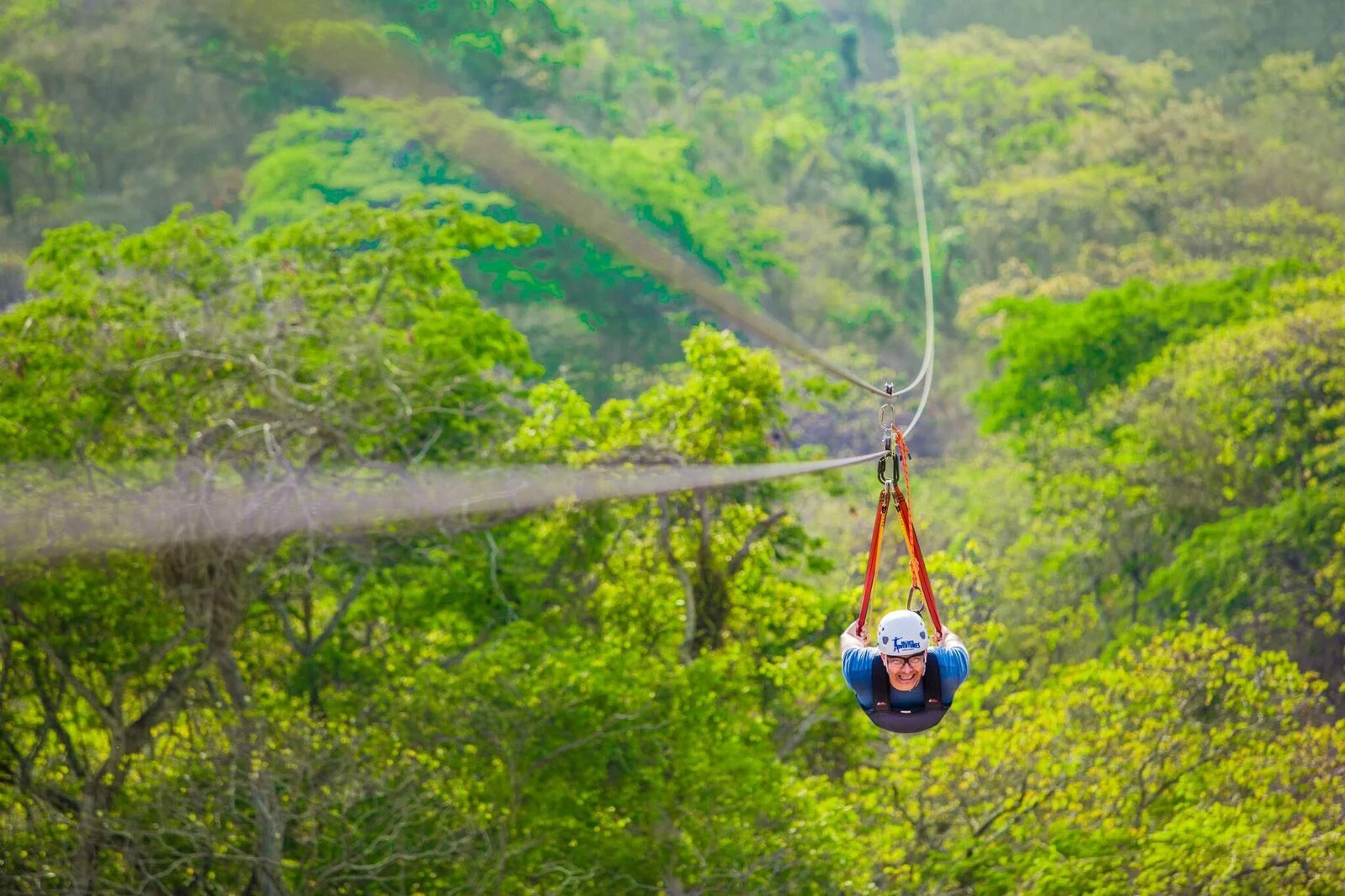 A person ziplining headfirst through the lush jungle, epitomizing the thrill of extreme vacations in Puerto Vallarta.