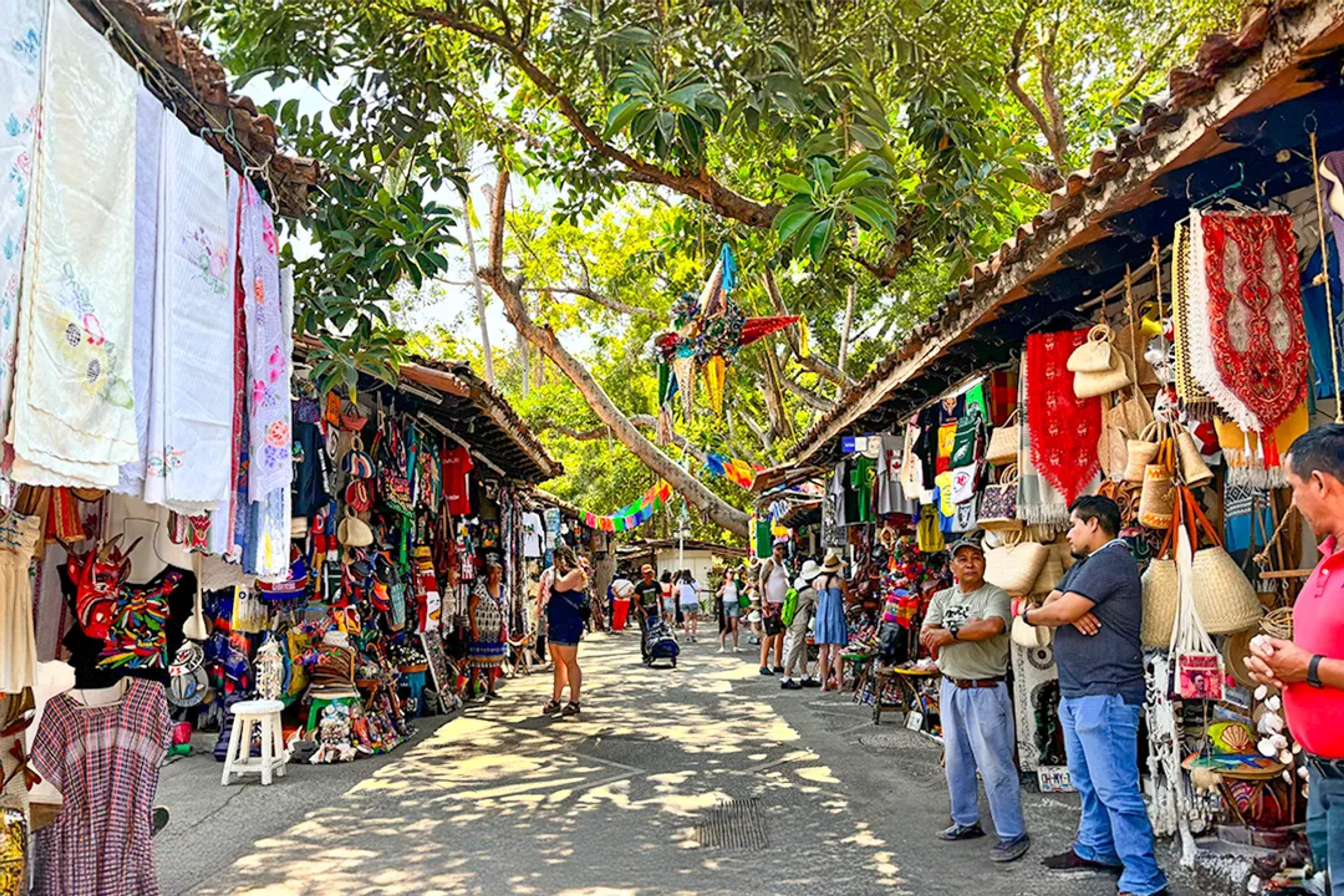 Mercado colorido en Puerto Vallarta con artesanías, textiles y souvenirs en un entorno vibrante al aire libre