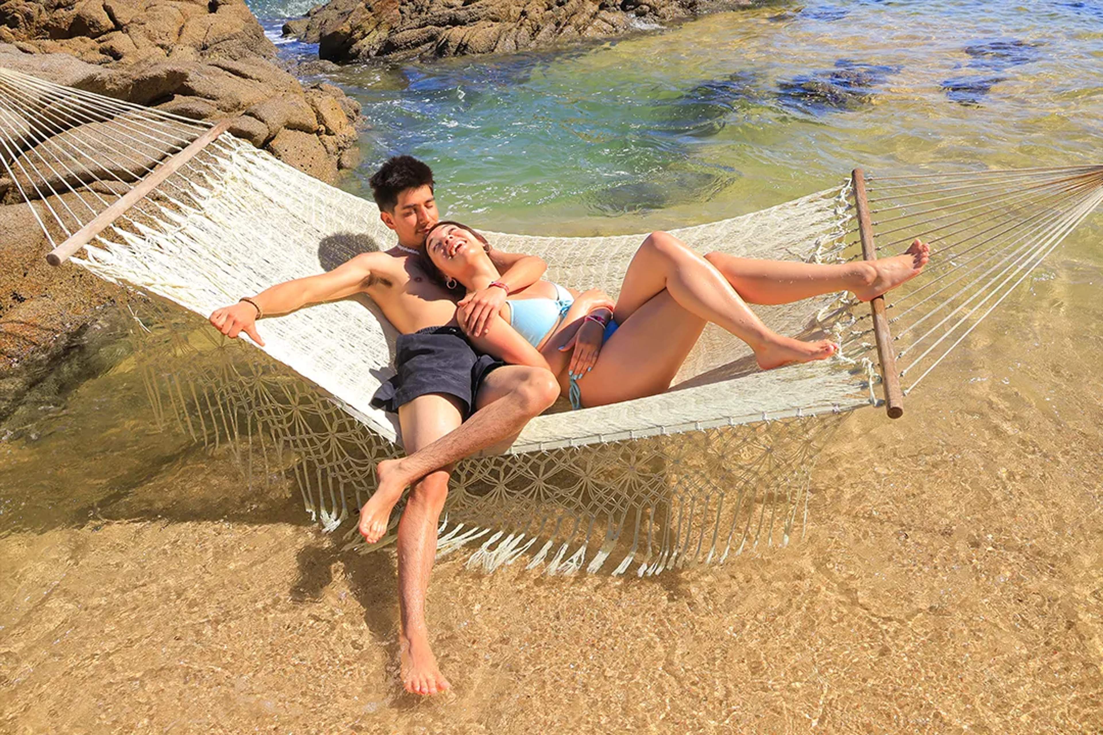 Couple relaxing in a hammock at Las Caletas Beach, Puerto Vallarta tropical getaway tour.