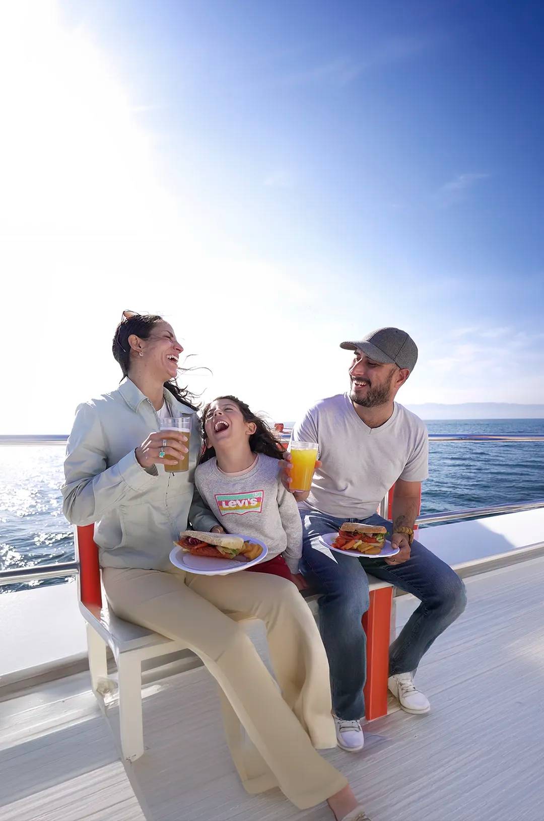 Family enjoying a delicious lunch on board a boat during a Puerto Vallarta whale watching tour.