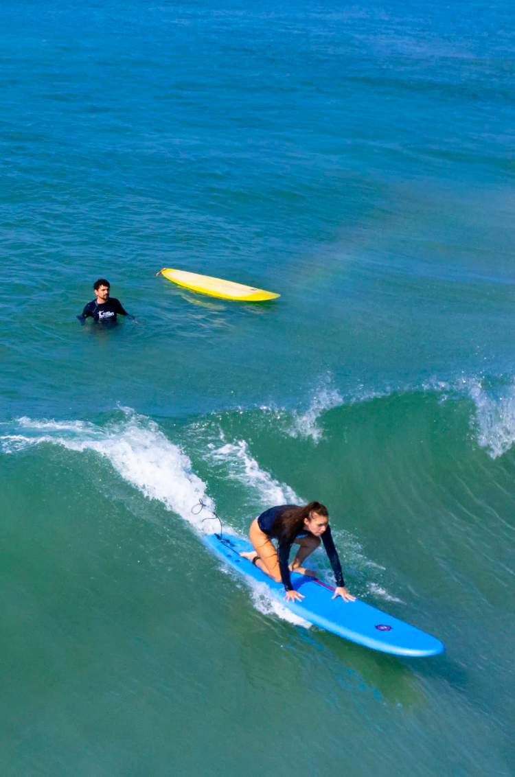 Private Surf Lesson in Punta Mita with instructor helping beginner ride a Pacific wave.