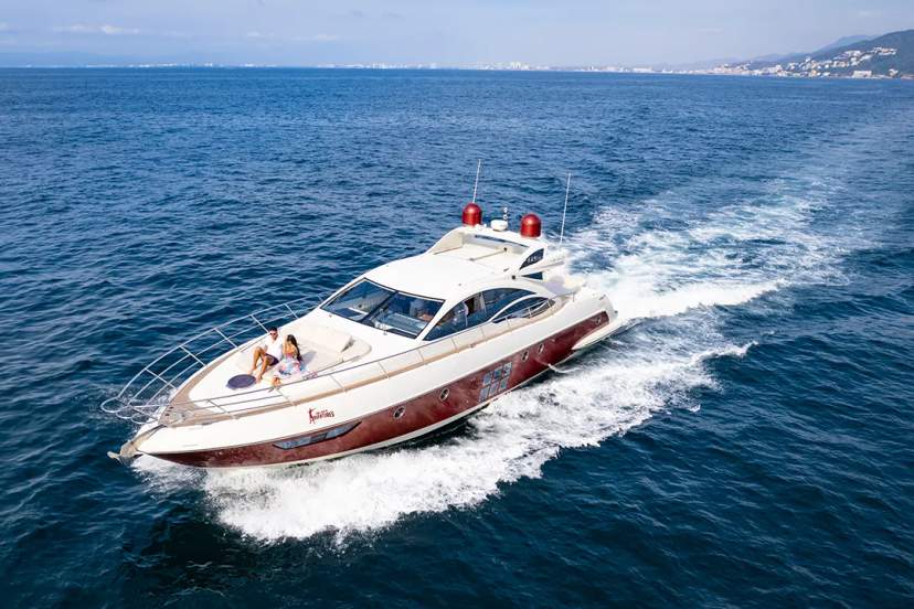 Elegant yacht cruising at high speed, with a couple relaxing on the deck under the sun.