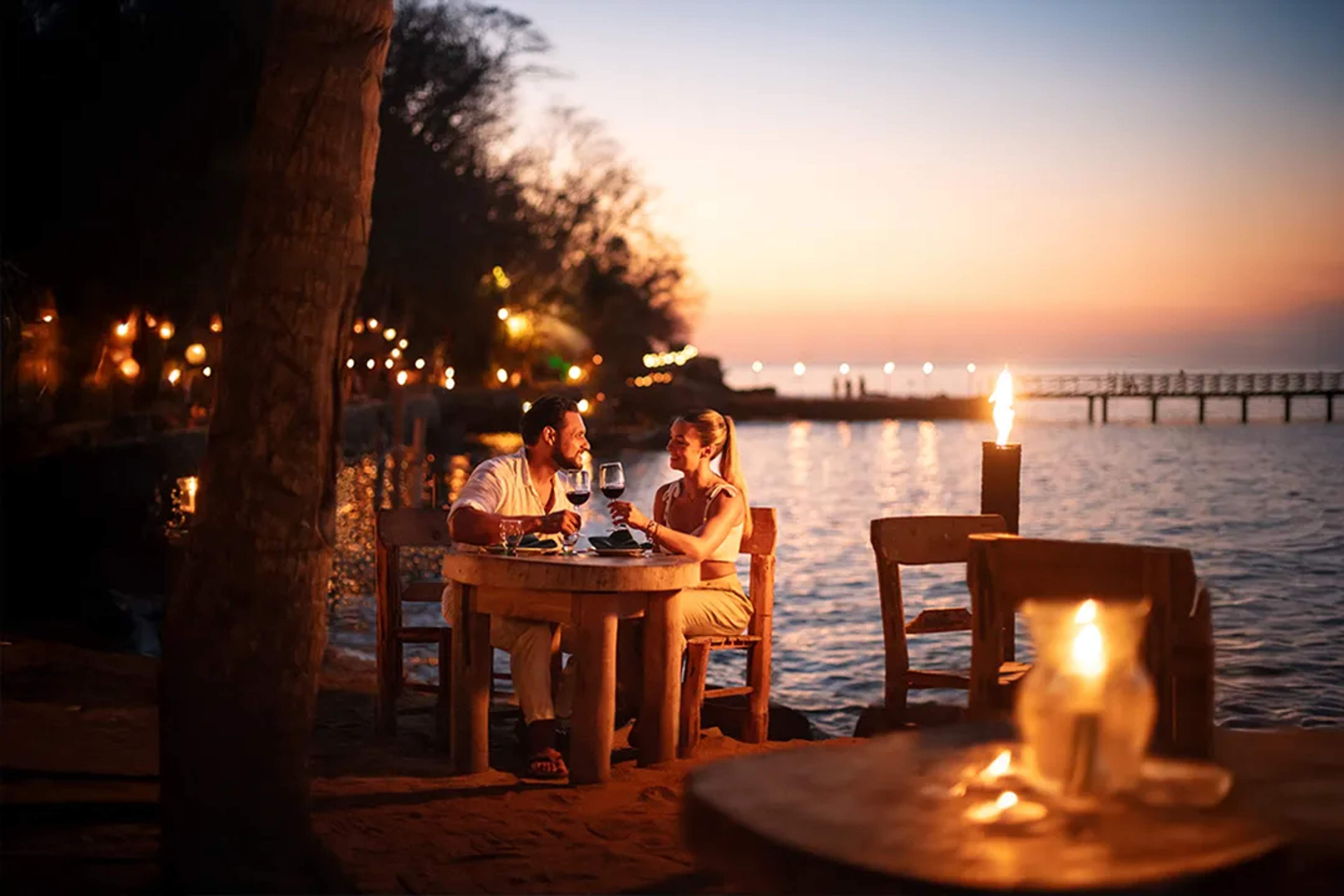 Romantic oceanfront dinner at Las Caletas during Rhythms of the Night with candlelight and sunset views
