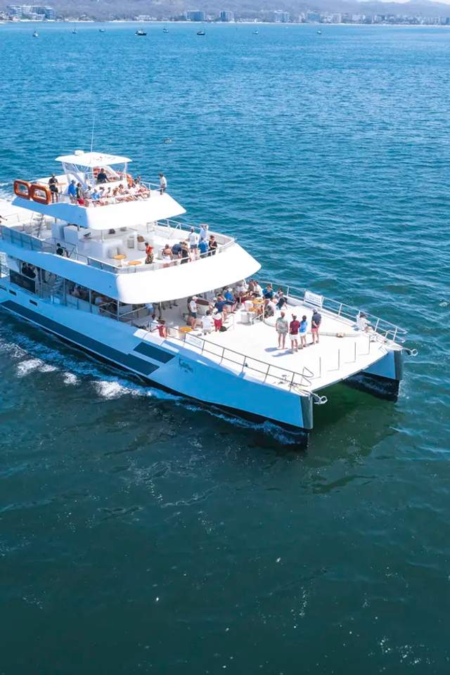 Seventeen Premium Catamaran sailing Banderas Bay in Puerto Vallarta with guests enjoying its three spacious decks.