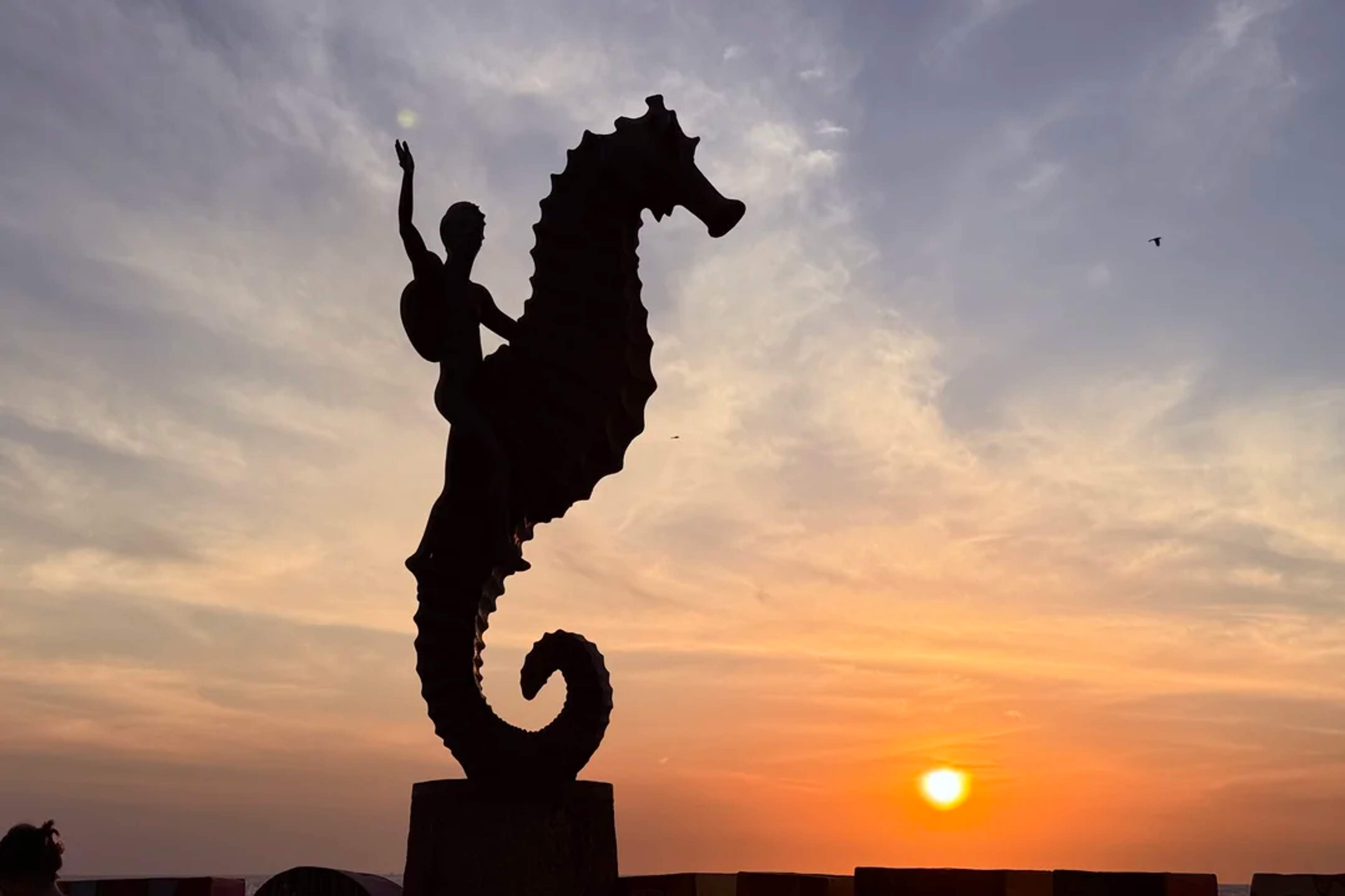 Sunset behind the iconic seahorse statue on the Puerto Vallarta Malecón.