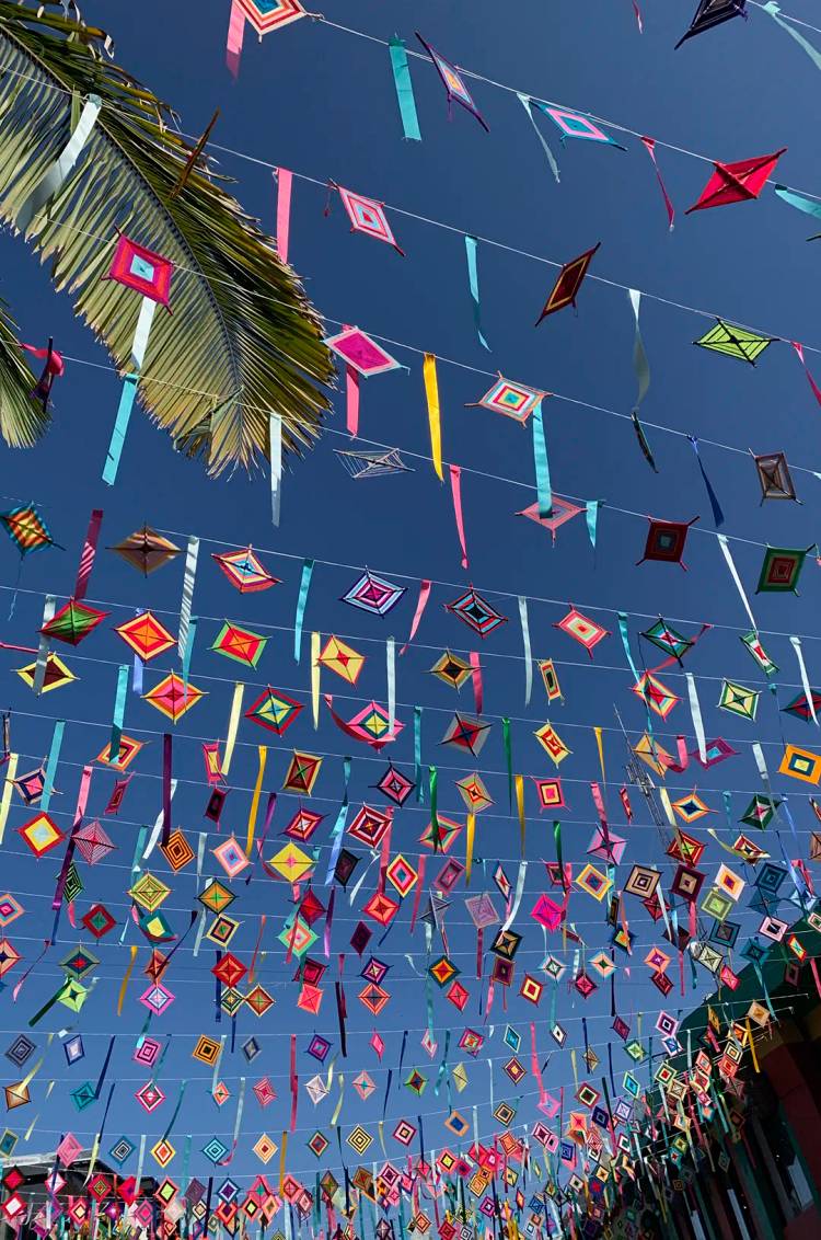 Coloridos Ojos de Dios, un amuleto de la cultura Wirarika, colgando en calle de Sayulita, México.