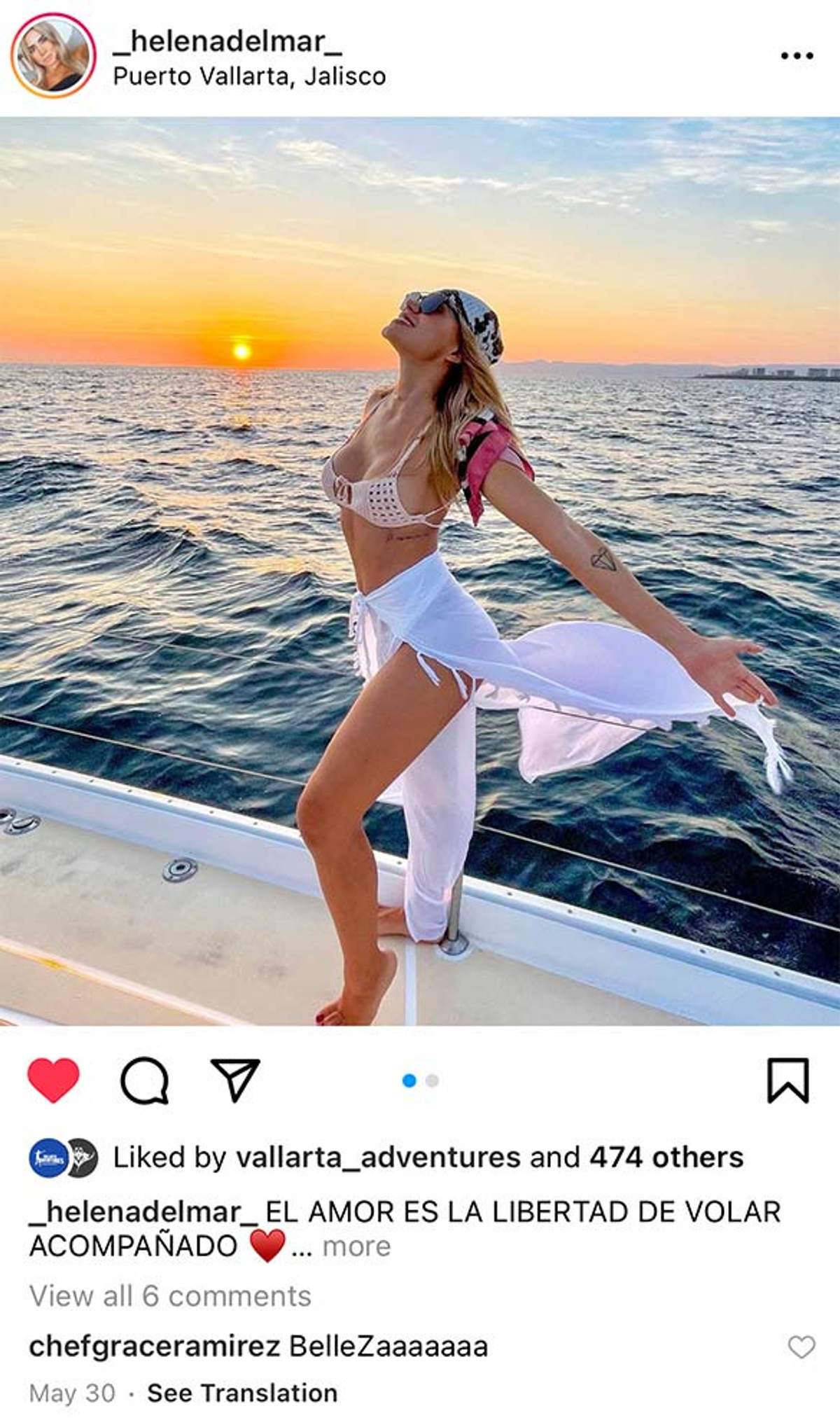 Mujer en un bote posando al atardecer en Puerto Vallarta, con bikini y pareo blanco, con el océano de fondo.
