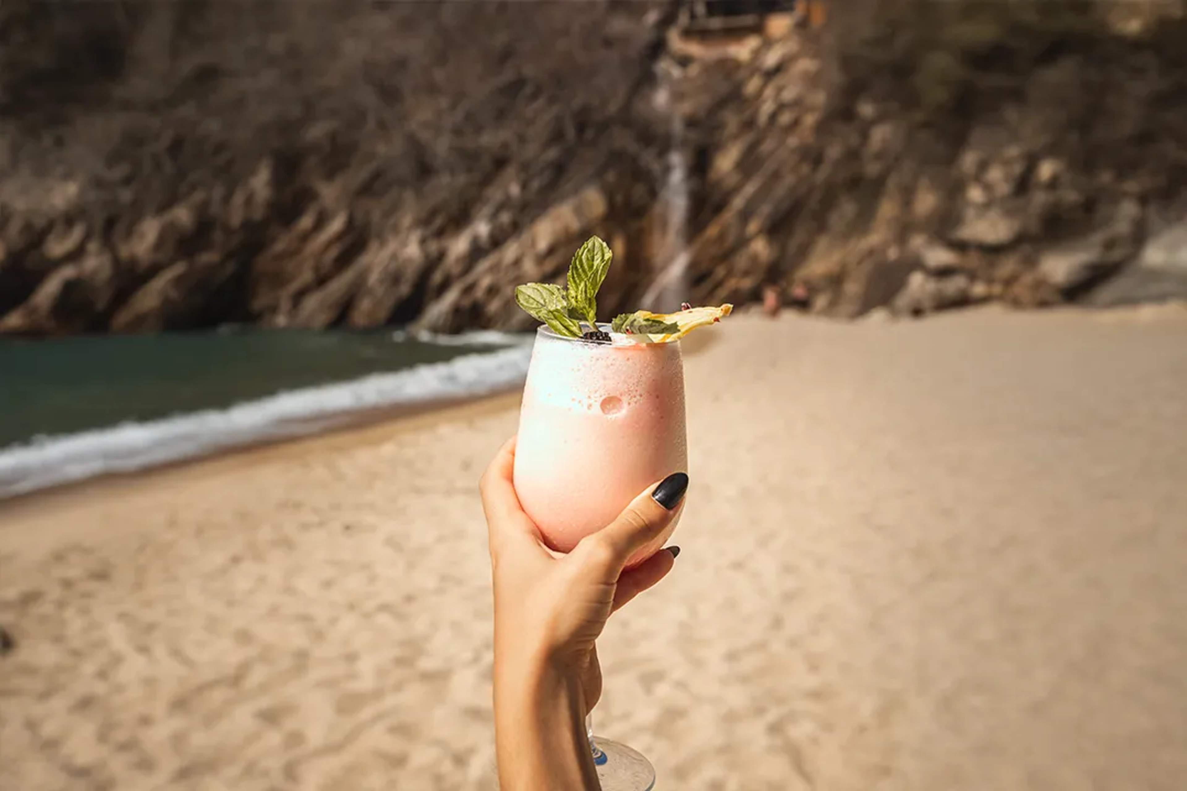 Pink tropical cocktail enjoyed on a secluded beach during a luxury Puerto Vallarta coastal tour