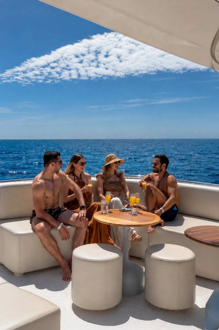 Friends enjoy premium drinks aboard the Seventeen Catamaran while cruising the blue waters of Los Cabos.