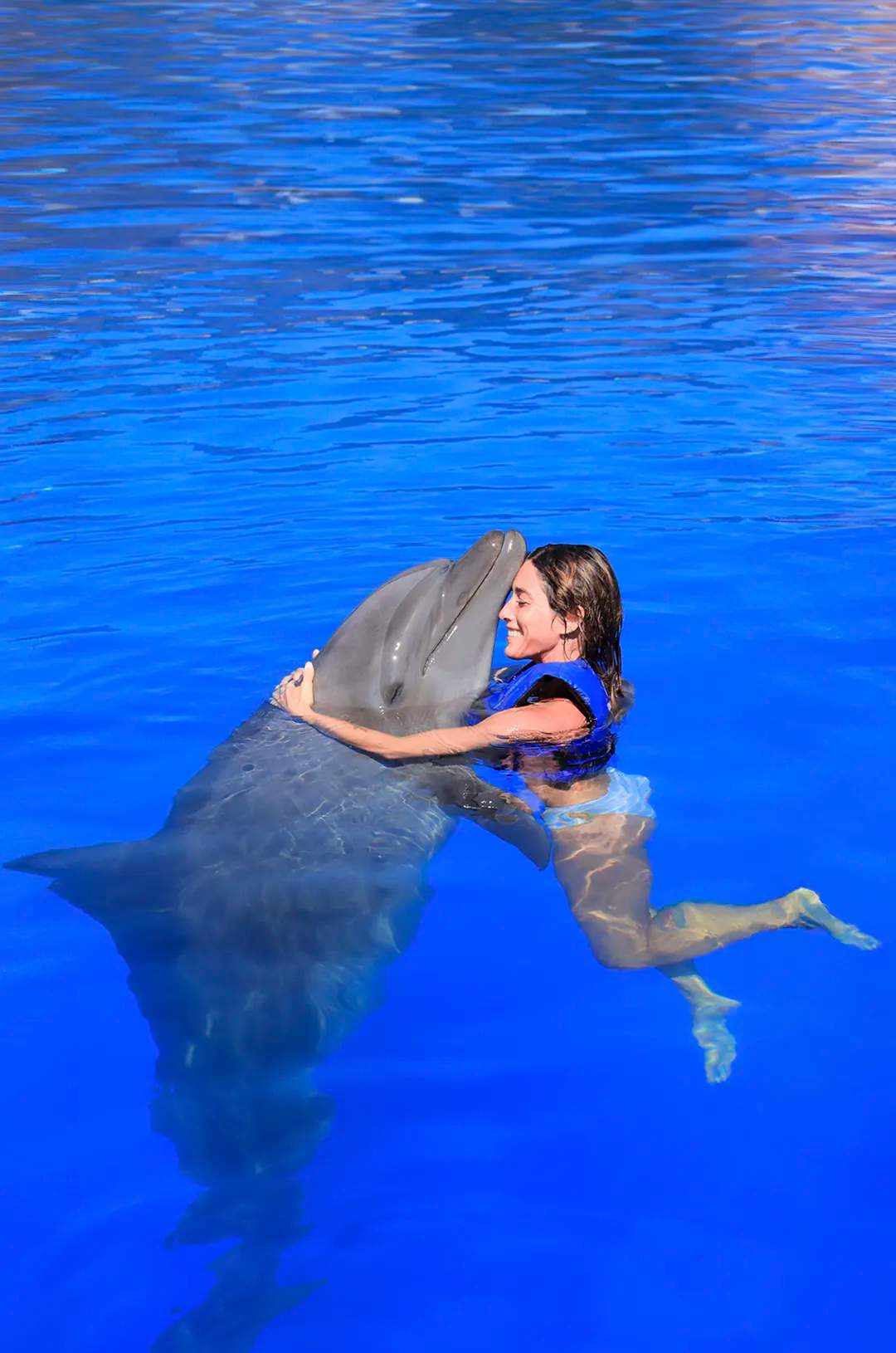 Chica en un momento tierno con delfines en Puerto Vallarta.
