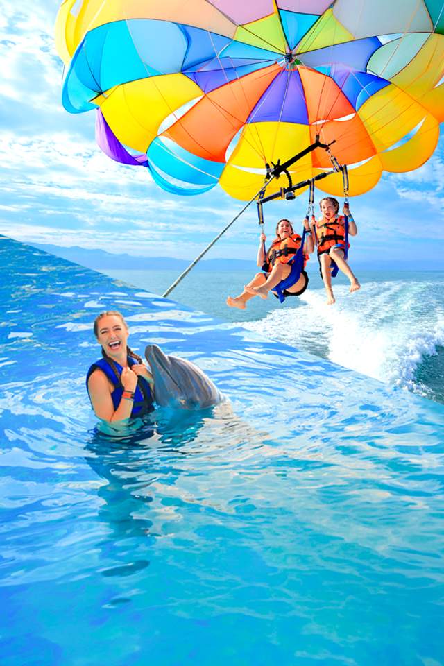Fly on a parasailing and swim with dolphins in a Puerto Vallarta tour package.