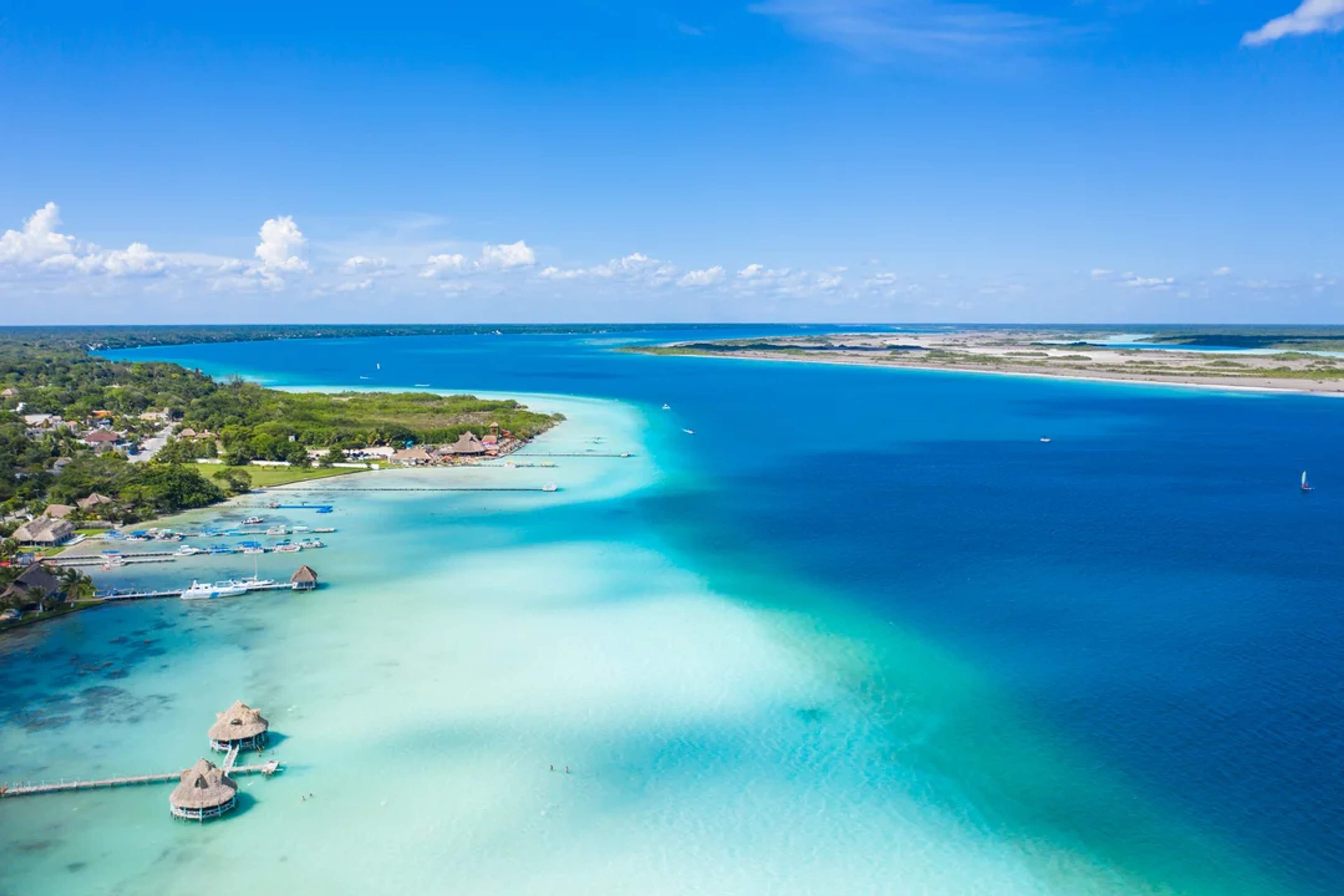 A stunning aerial view of Bacalar Lagoon, showcasing its vibrant blue hues and peaceful tropical scenery.