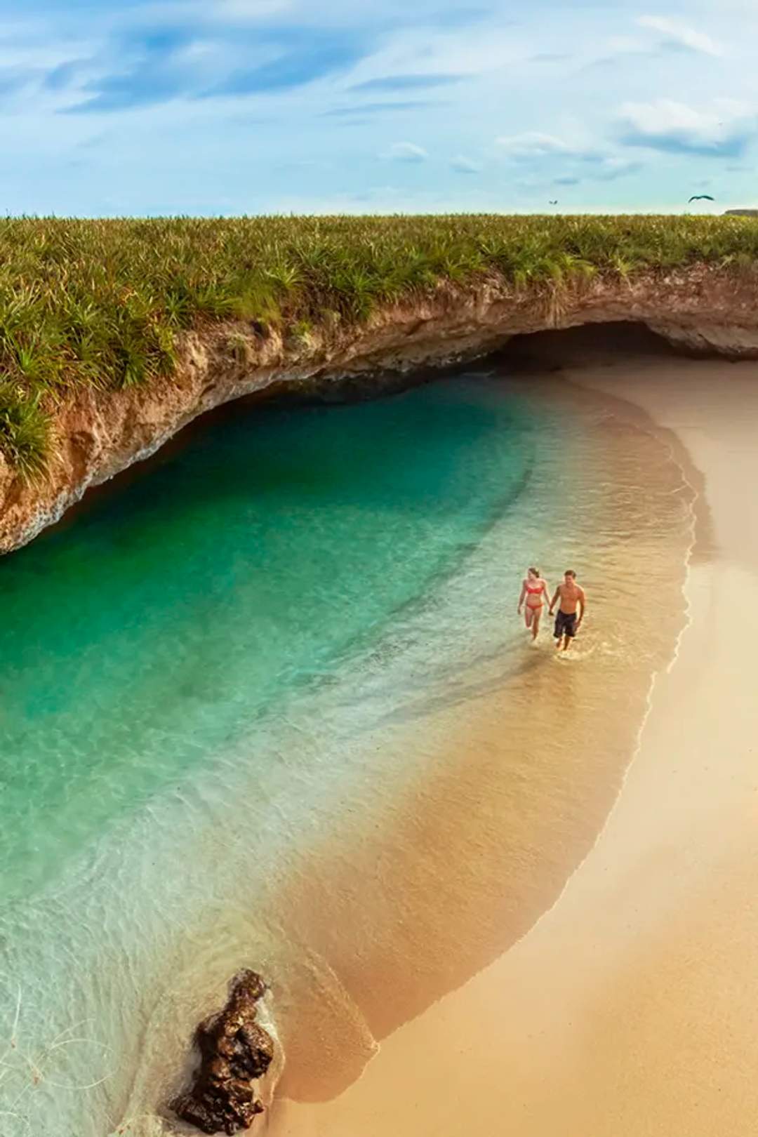A couple embraces in the clear waters of Hidden Beach, Marietas Islands.