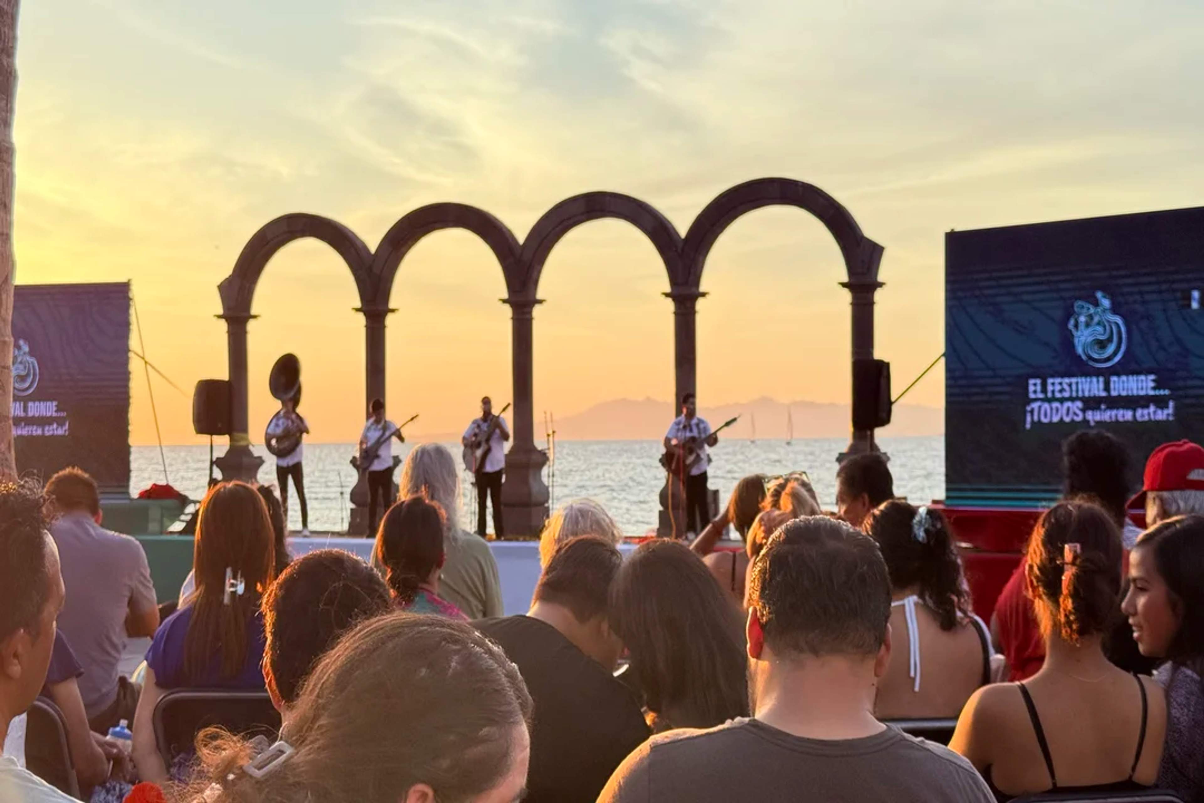 Live music at sunset on the Puerto Vallarta Malecón, with the iconic arches and ocean view.