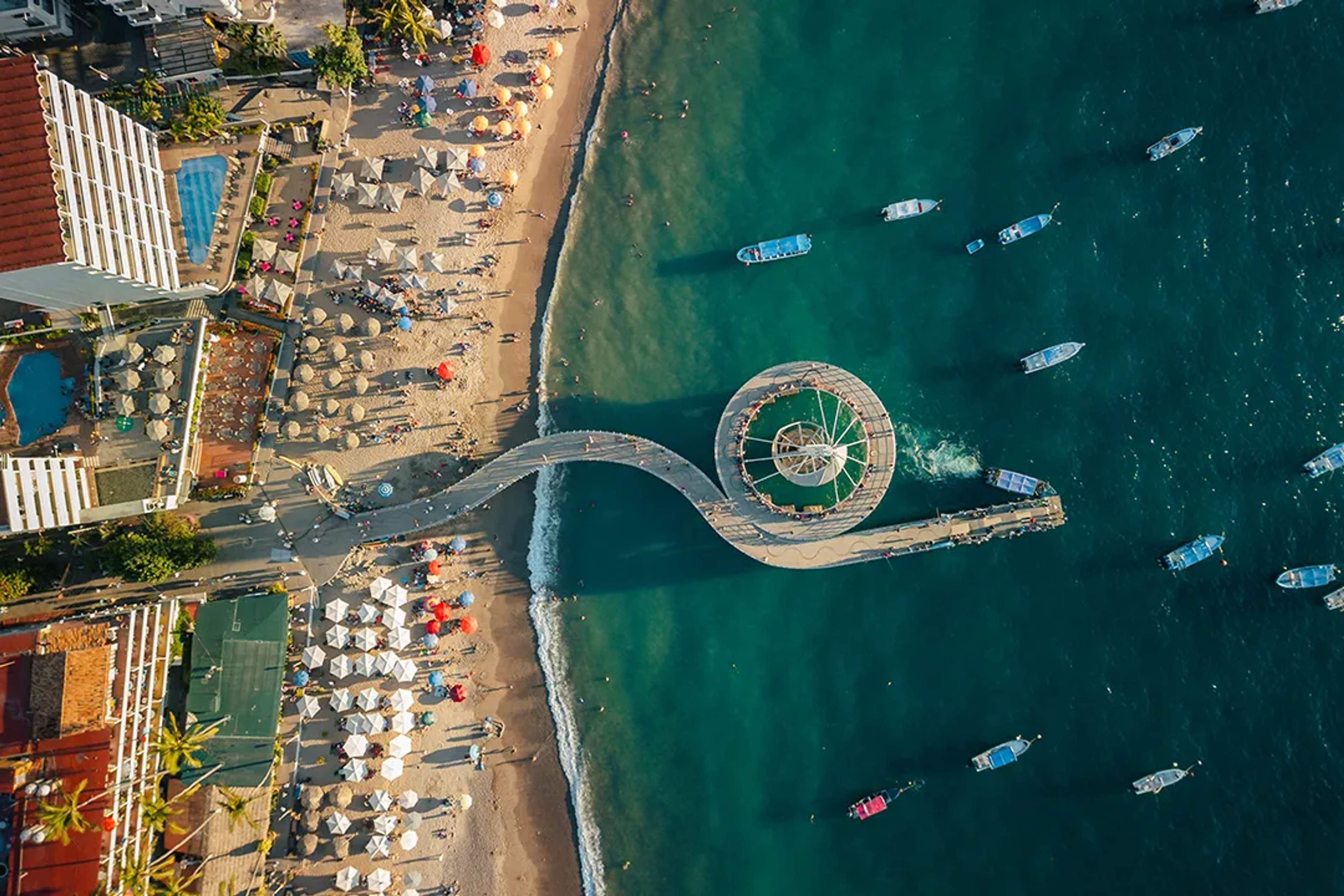 Aerial view of Los Muertos Pier and beach in Puerto Vallarta with boats and turquoise Pacific waters