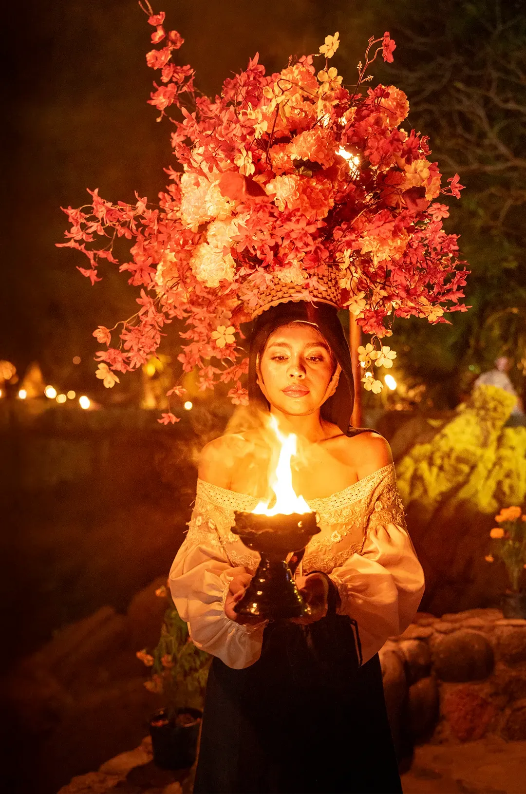 Artista con tocado floral y ofrenda de fuego en ALMA, Ritmos de la Noche – Premier en Puerto Vallarta