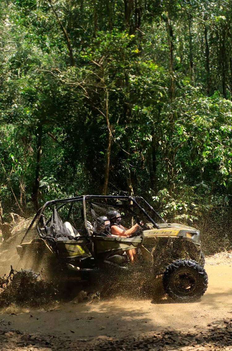 An ATV through a muddy trail in a forest during a Puerto Vallarta off-road tour.
