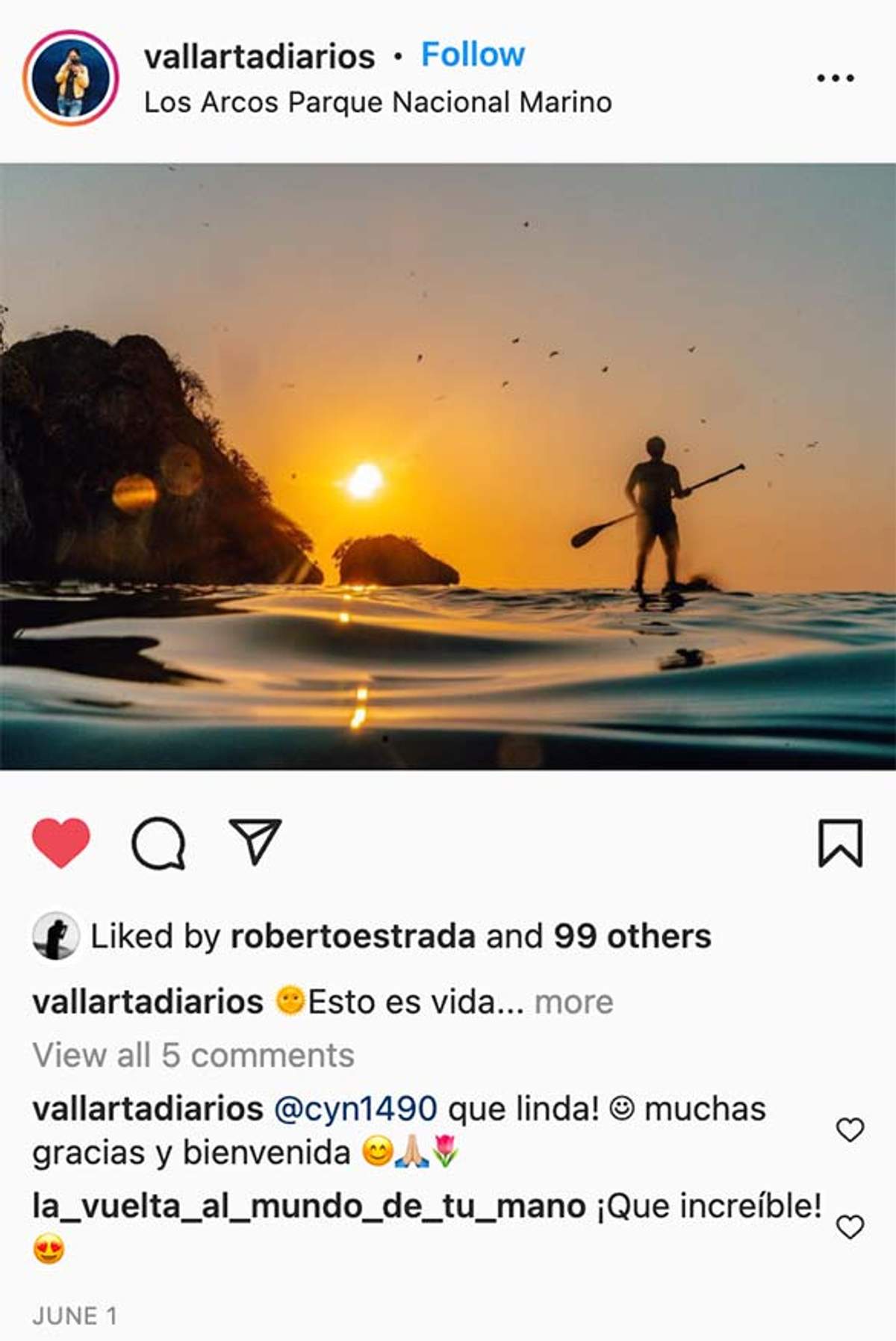 Persona practicando paddleboard al atardecer cerca de las formaciones rocosas del Parque Nacional Marino Los Arcos, con aves volando arriba.