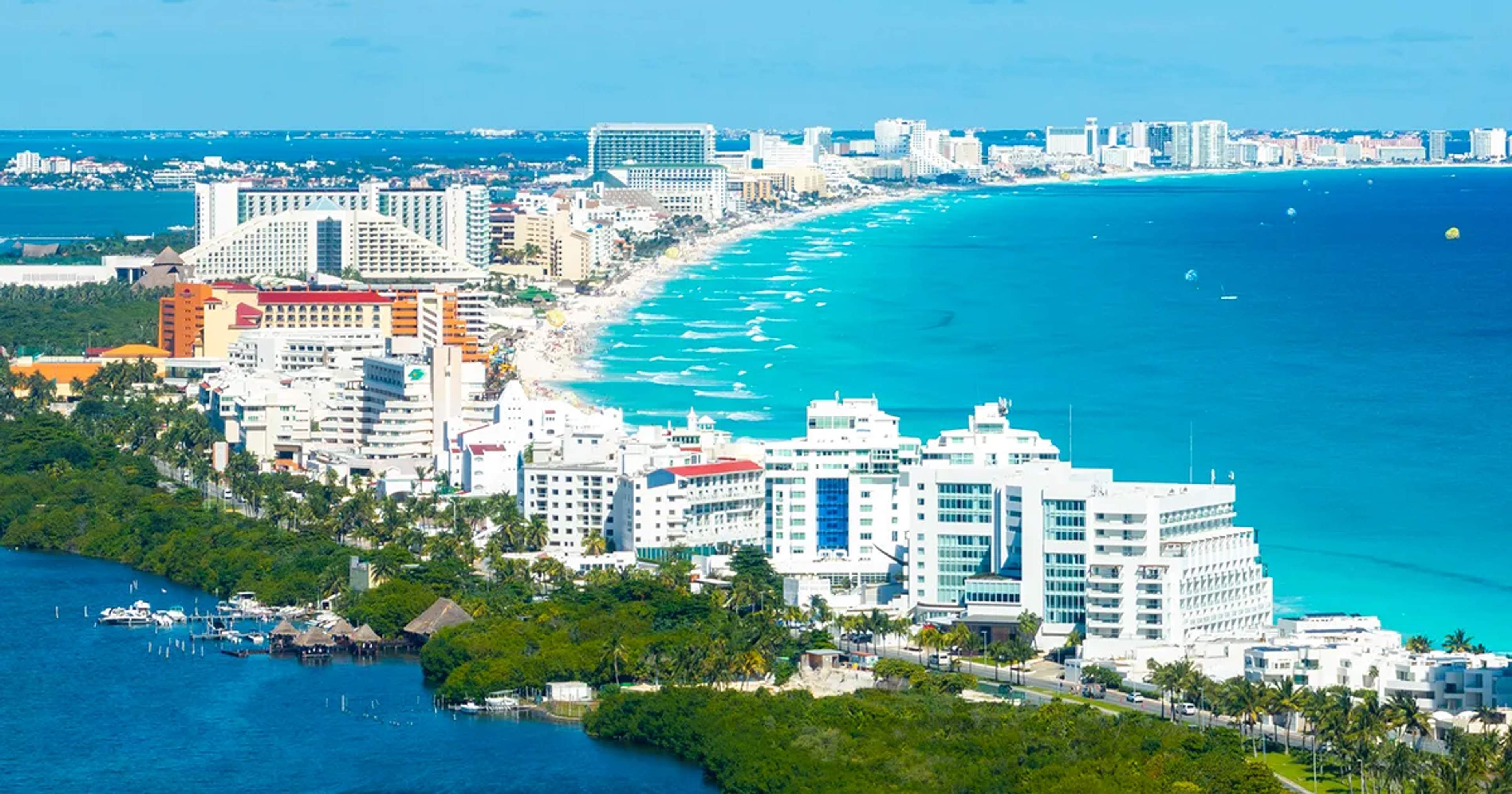 Vista aérea de la Zona Hotelera de Cancún, con mar Caribe turquesa, playas blancas y resorts frente al mar.