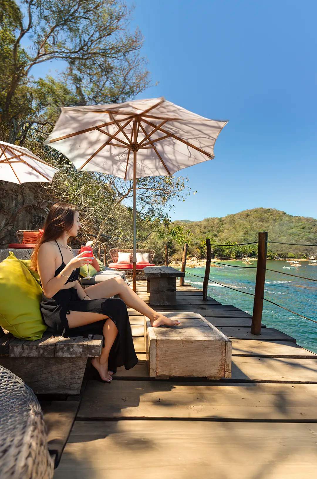 Woman enjoying a tropical cocktail at Las Caletas Puerto Vallarta.