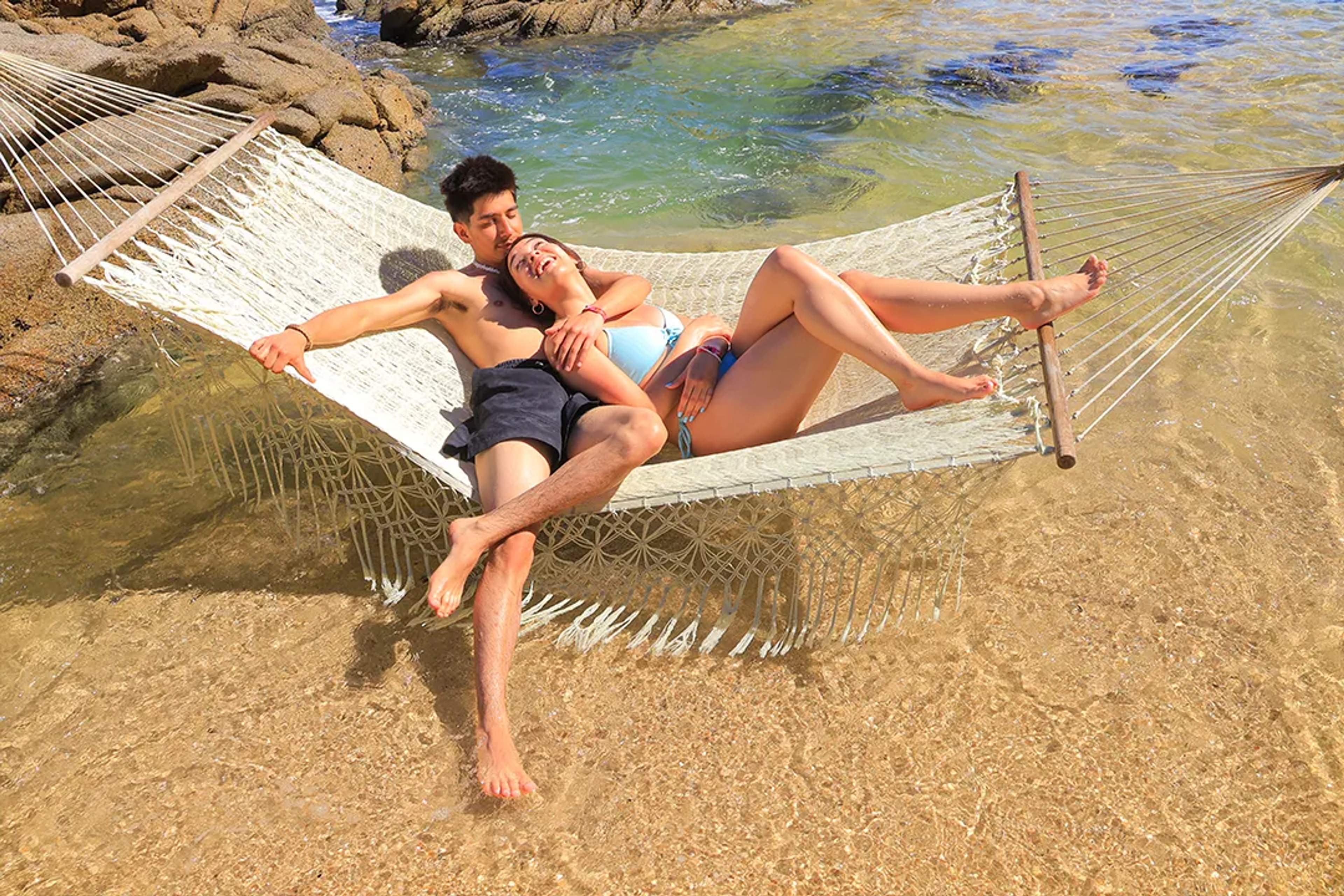 Couple relaxing together in a hammock by the ocean during a romantic Puerto Vallarta beach escape.