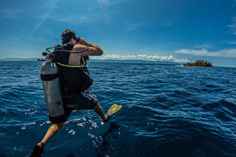 Diver makes a giant stride entry into the ocean, ready to explore the underwater world.