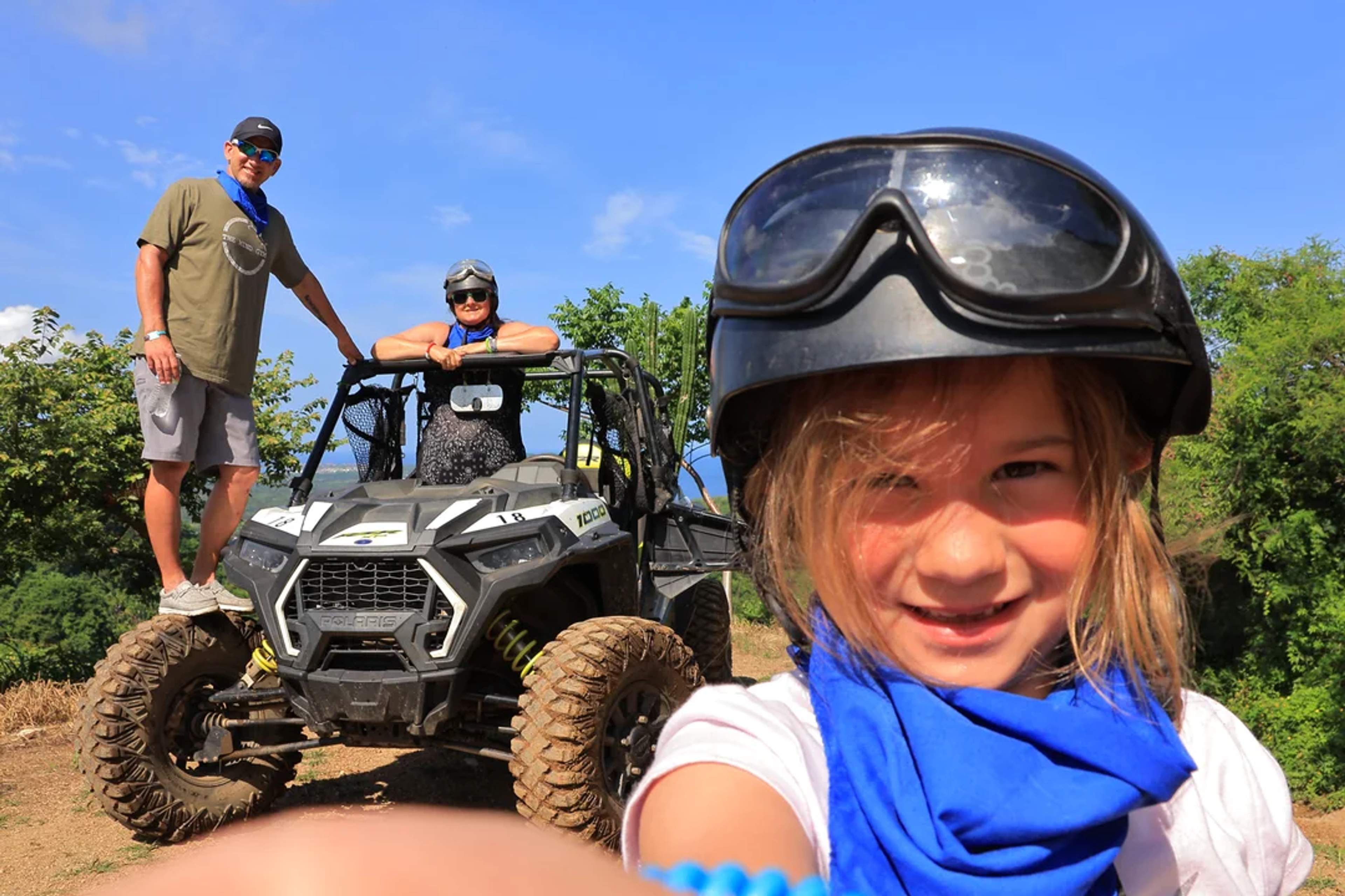 Familia toma una divertida selfie con su UTV tras una aventura todoterreno bajo el sol.