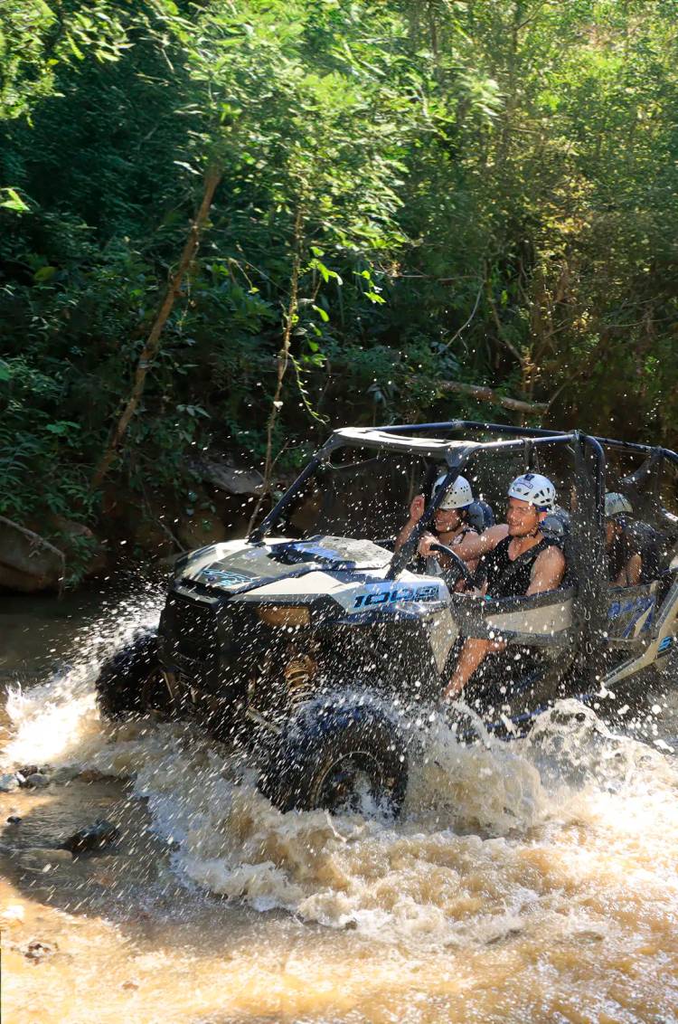 Adventurers splash through a creek in a Polaris RZR ATV in Puerto Vallarta on the Extreme Adventure tour.