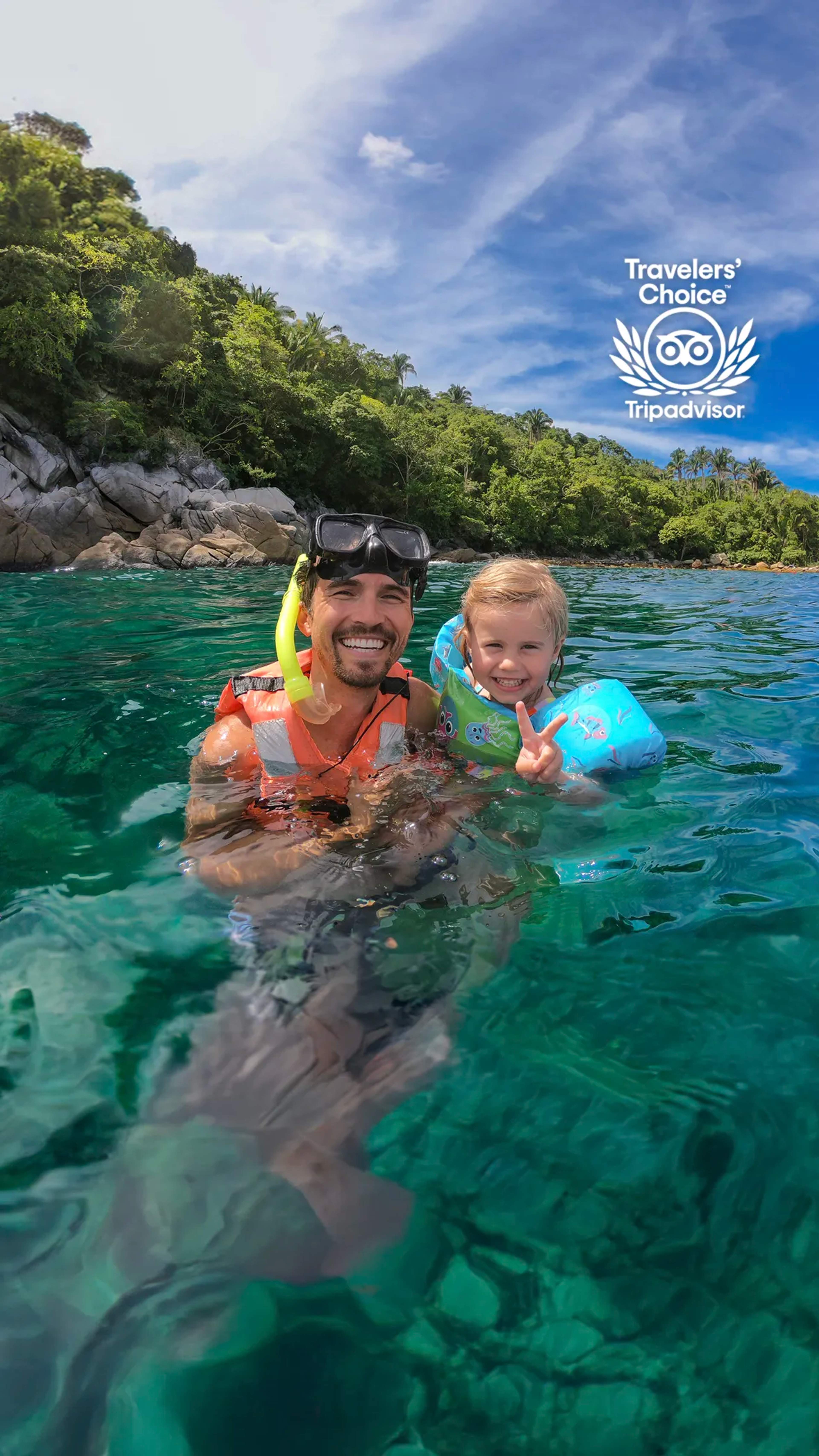 Tour familiar de snorkel en Puerto Vallarta con padre e hijo nadando en aguas claras cerca de la costa