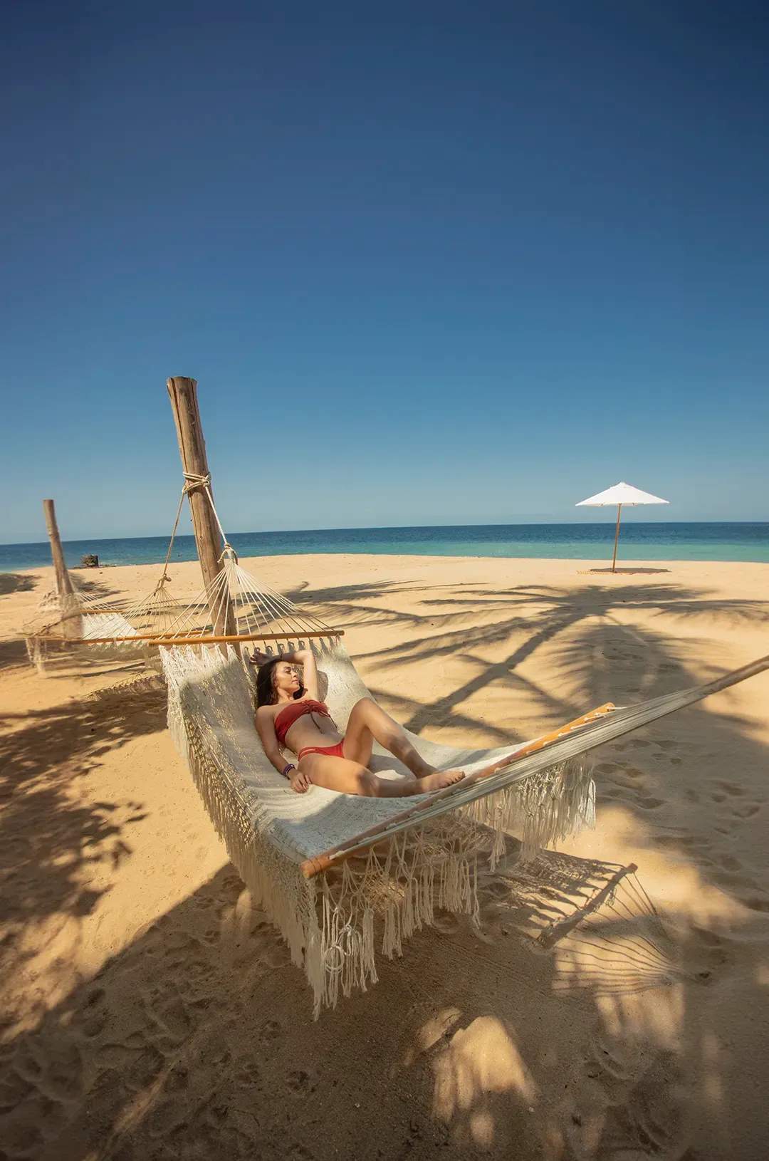 Woman relaxing on a hammock in Pizota, a secluded beach near Puerto Vallarta.
