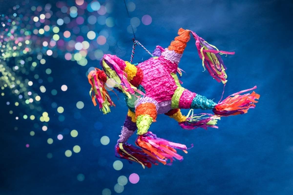 Colorful piñata with streamers against a sparkling background, representing festive Christmas celebrations in Mexico.