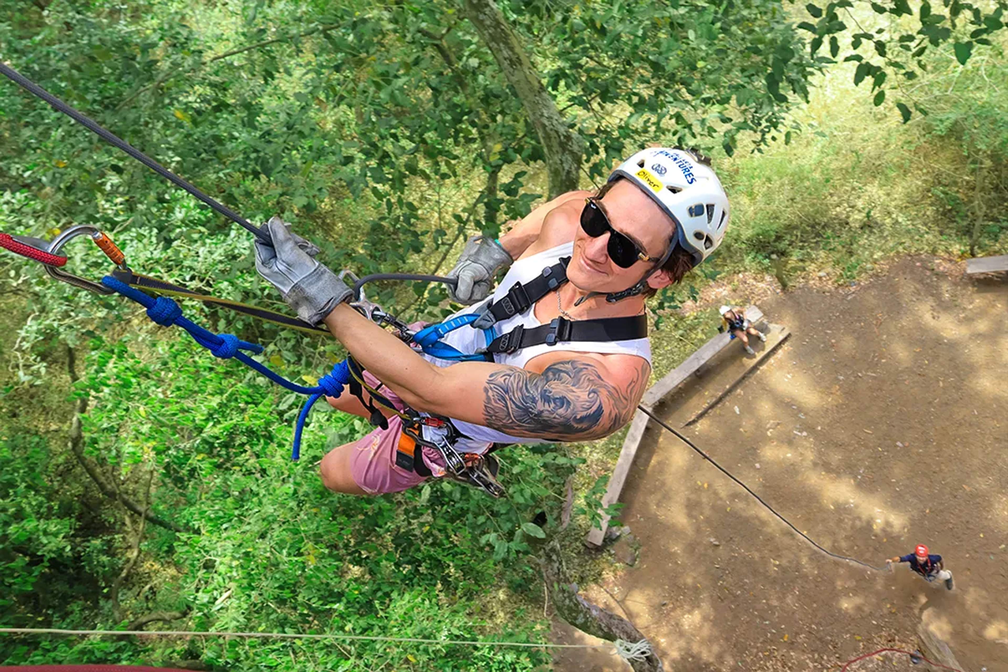 Aventurero desciende en rappel por una plataforma en la selva, en Extreme Adventure.