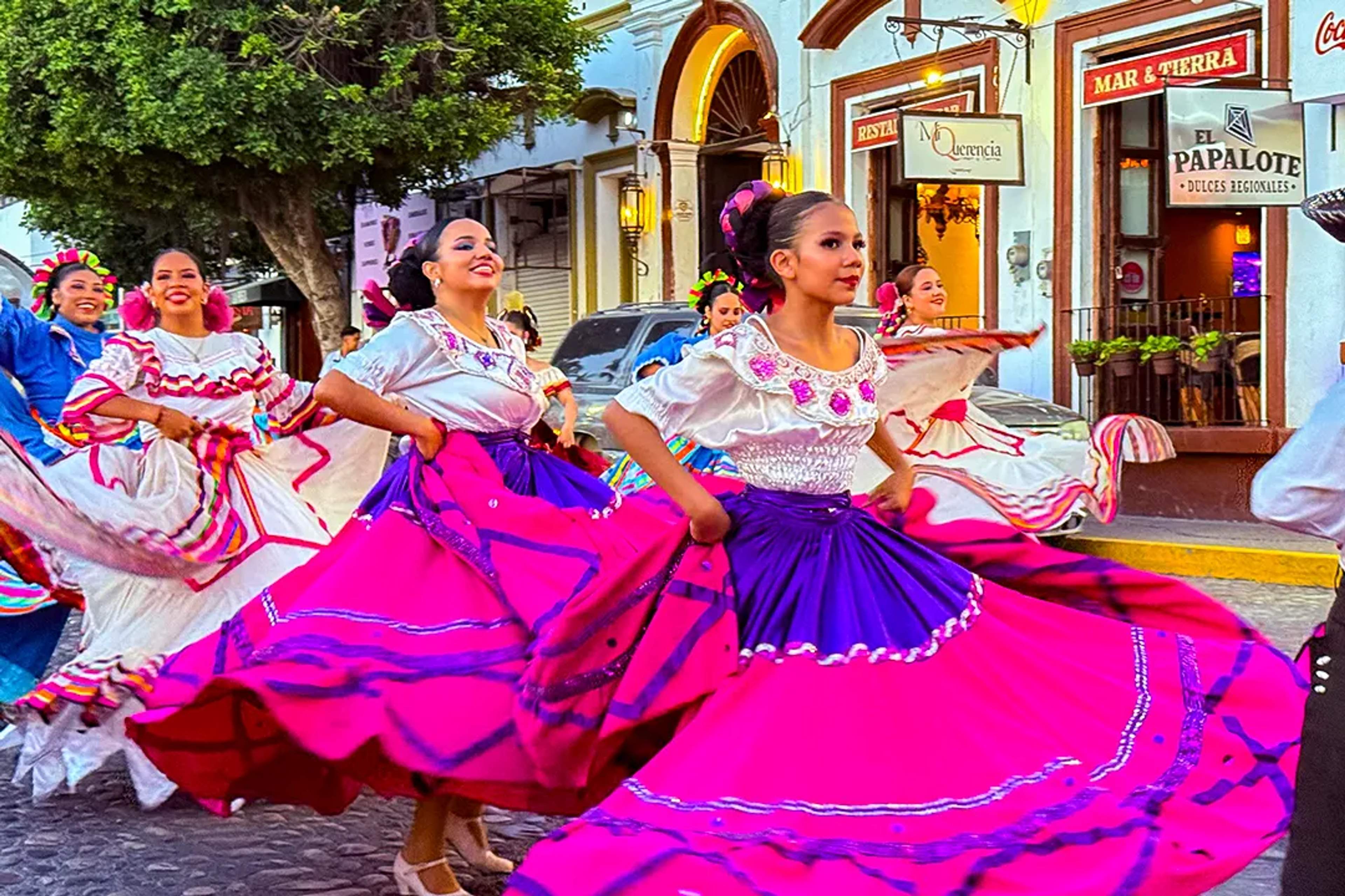 Bailarinas folclóricas giran coloridos vestidos en una danza tradicional mexicana en calles de Puerto Vallarta