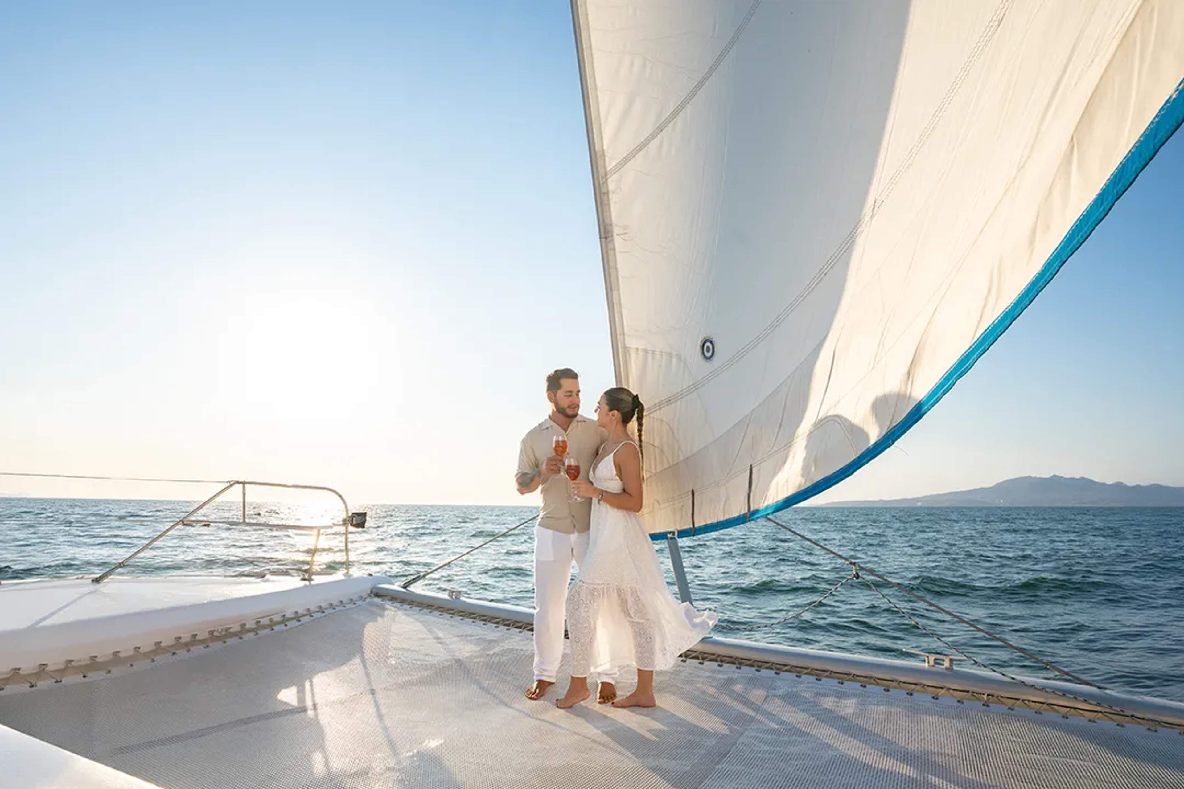 Couple enjoying a romantic Sunset Sailing experience on a catamaran in Puerto Vallarta with ocean views