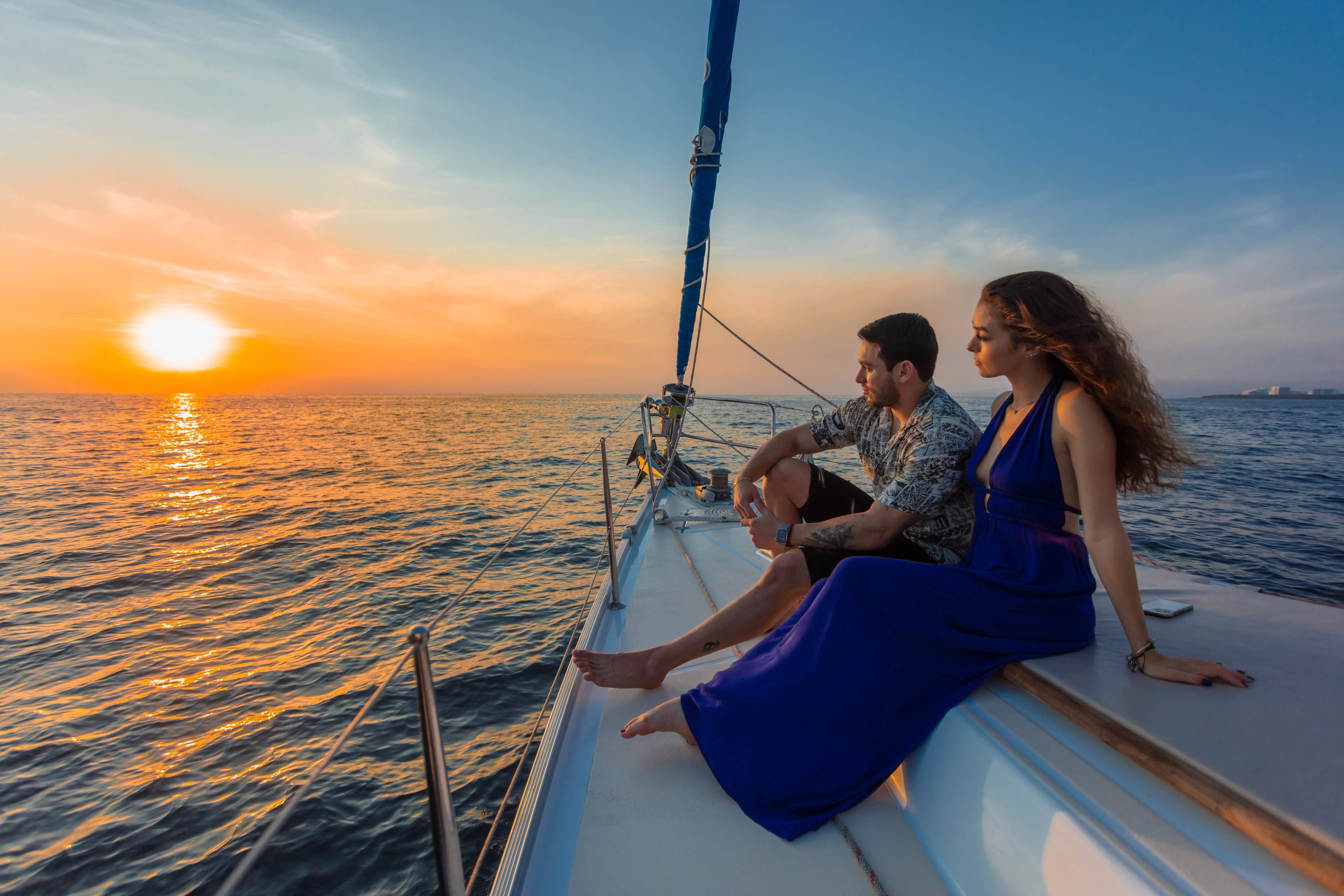 Couple sitting on a yacht watching the sunset.
