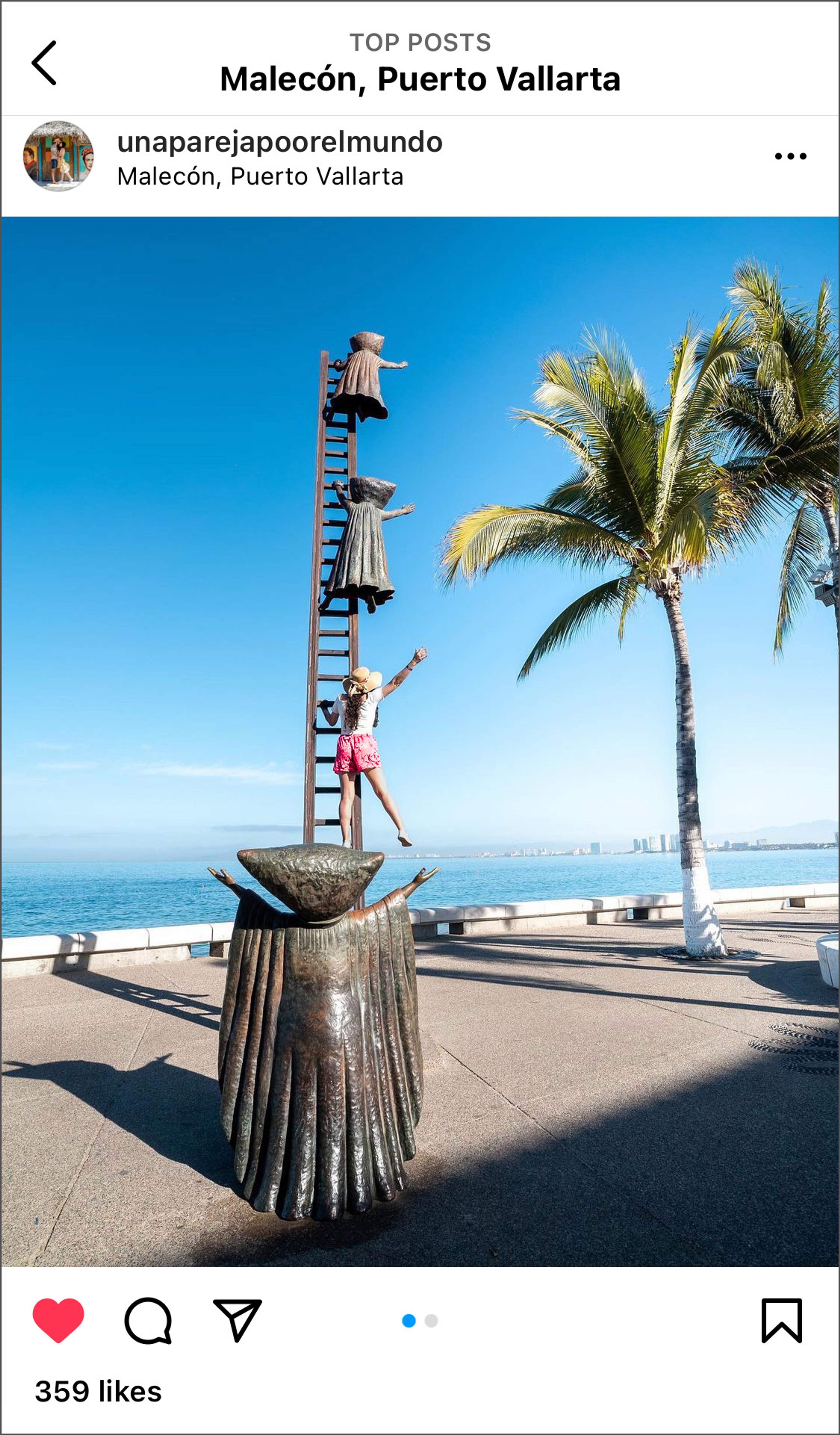 Woman climbing sculpture on the Malecon in Puerto Vallarta with palm tree and ocean in the background.