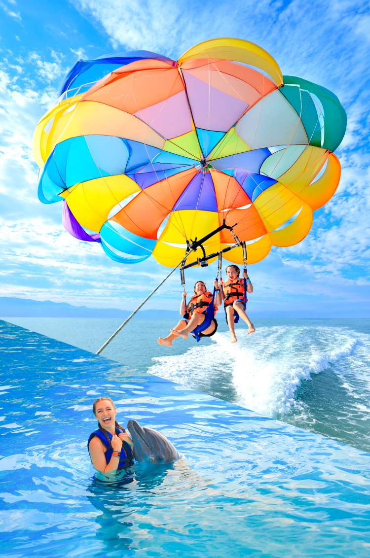 Fly on a parasailing and swim with dolphins in a Puerto Vallarta tour package.