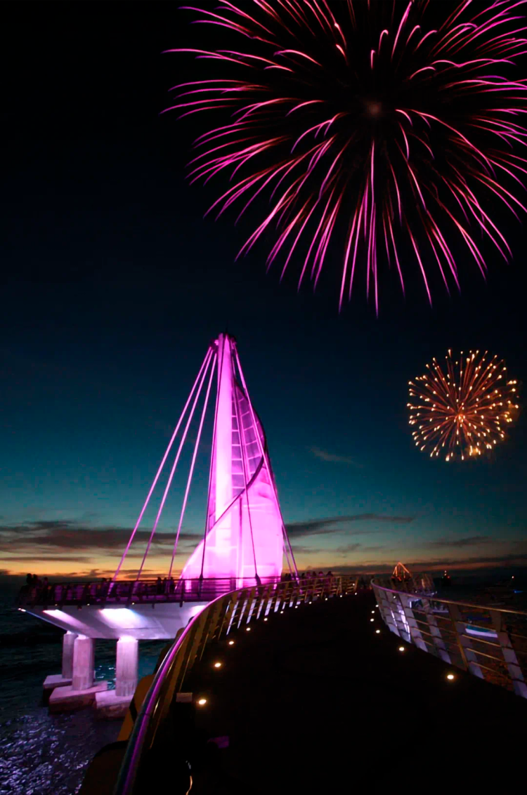 Los Muertos Pier at night, illuminated by the New Year's Eve fireworks in Puerto Vallarta.