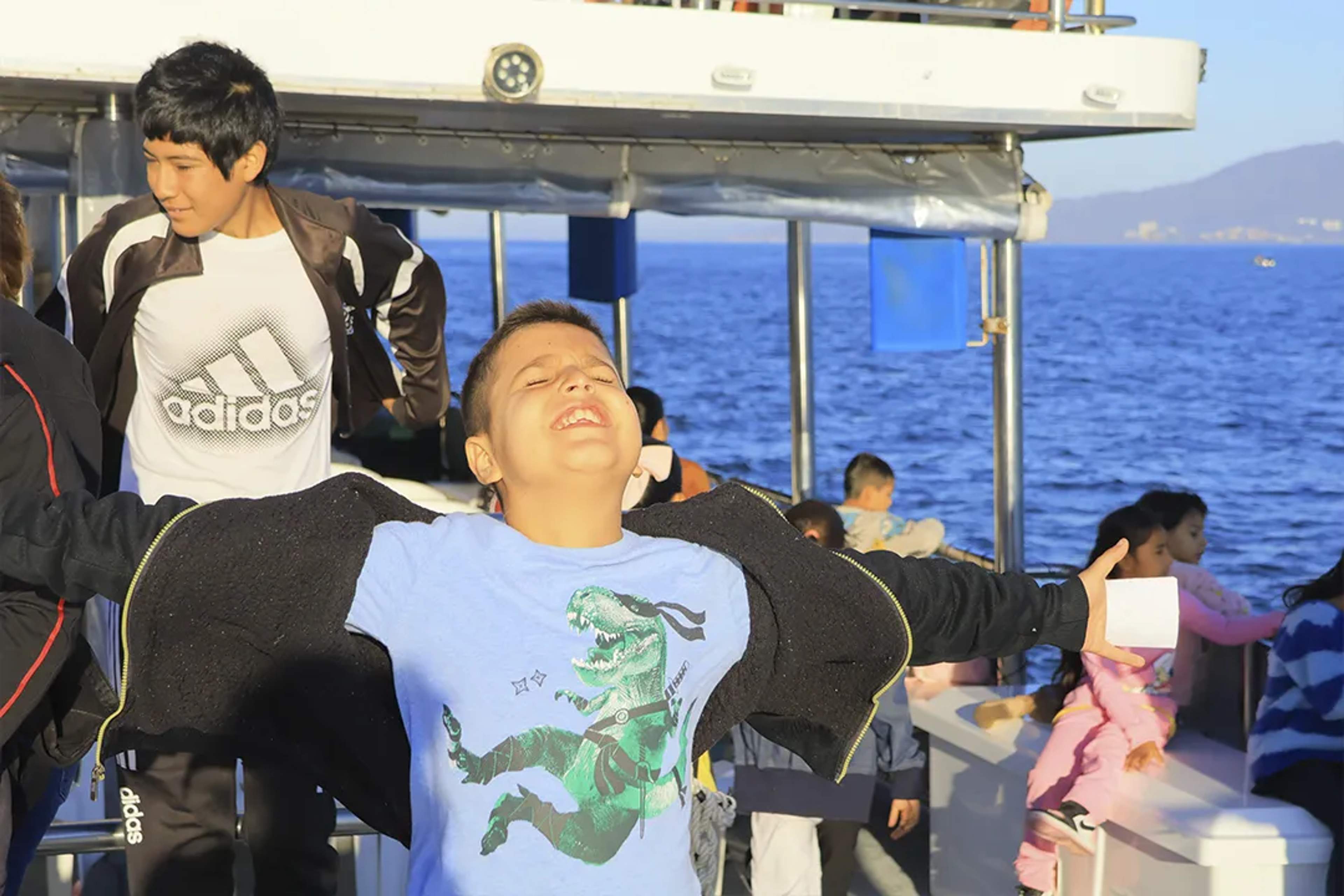 Niño sintiendo la brisa del mar