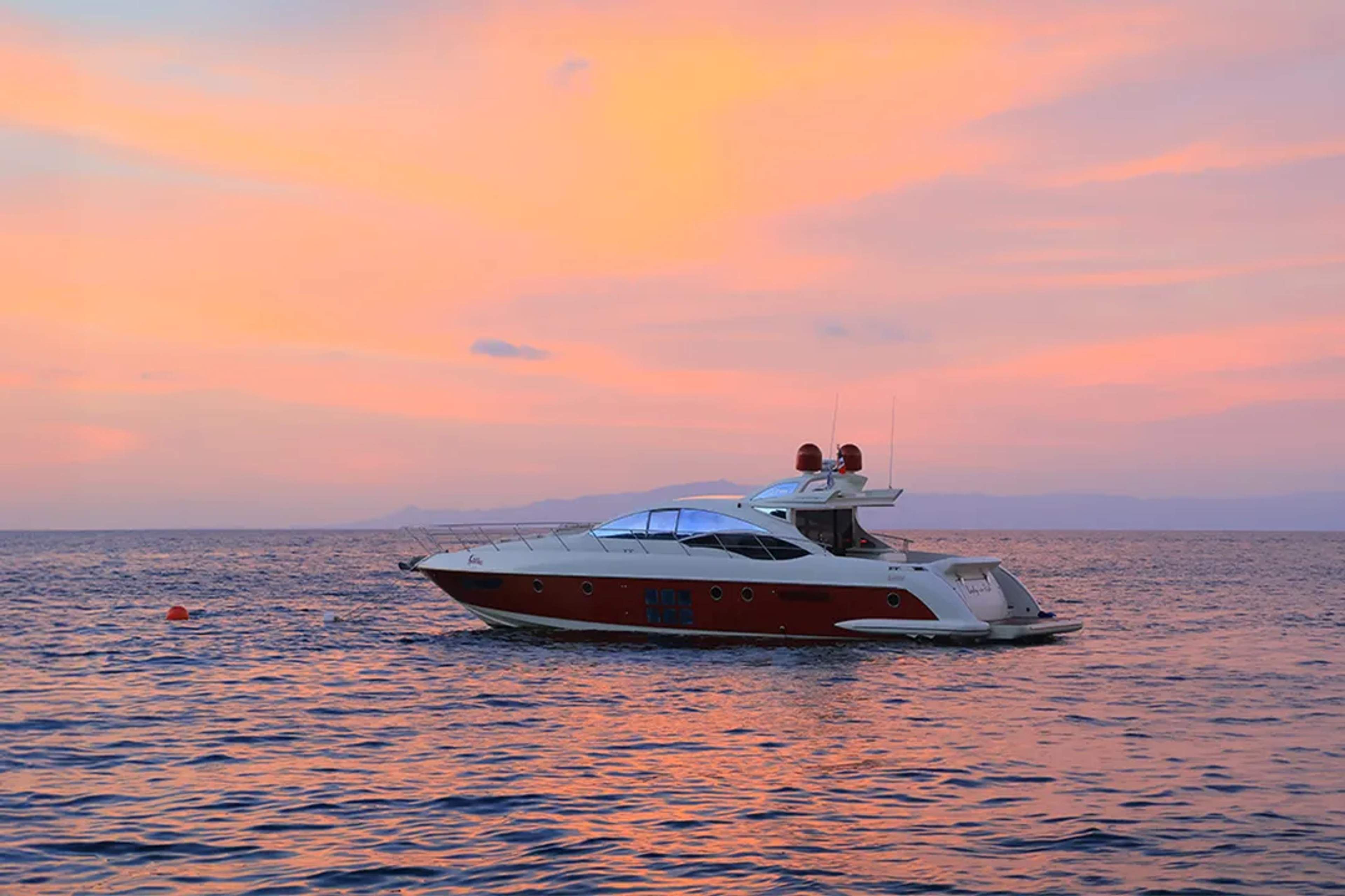 Yate privado al atardecer en Puerto Vallarta, una experiencia de lujo con vistas al mar y cielos dorados.