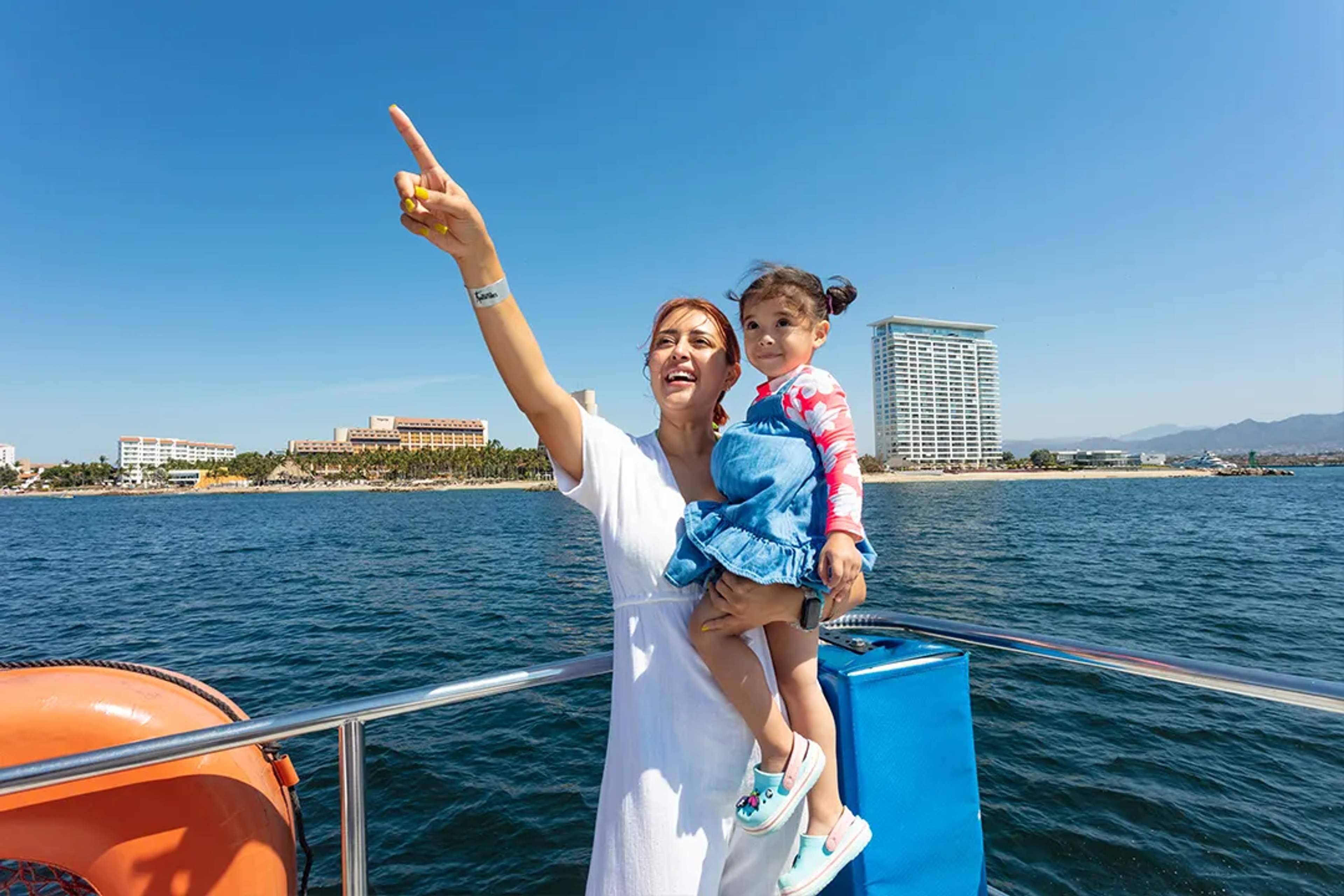 Mother and child enjoying boat tour in Puerto Vallarta with skyline views of Banderas Bay on Majahuitas cruise