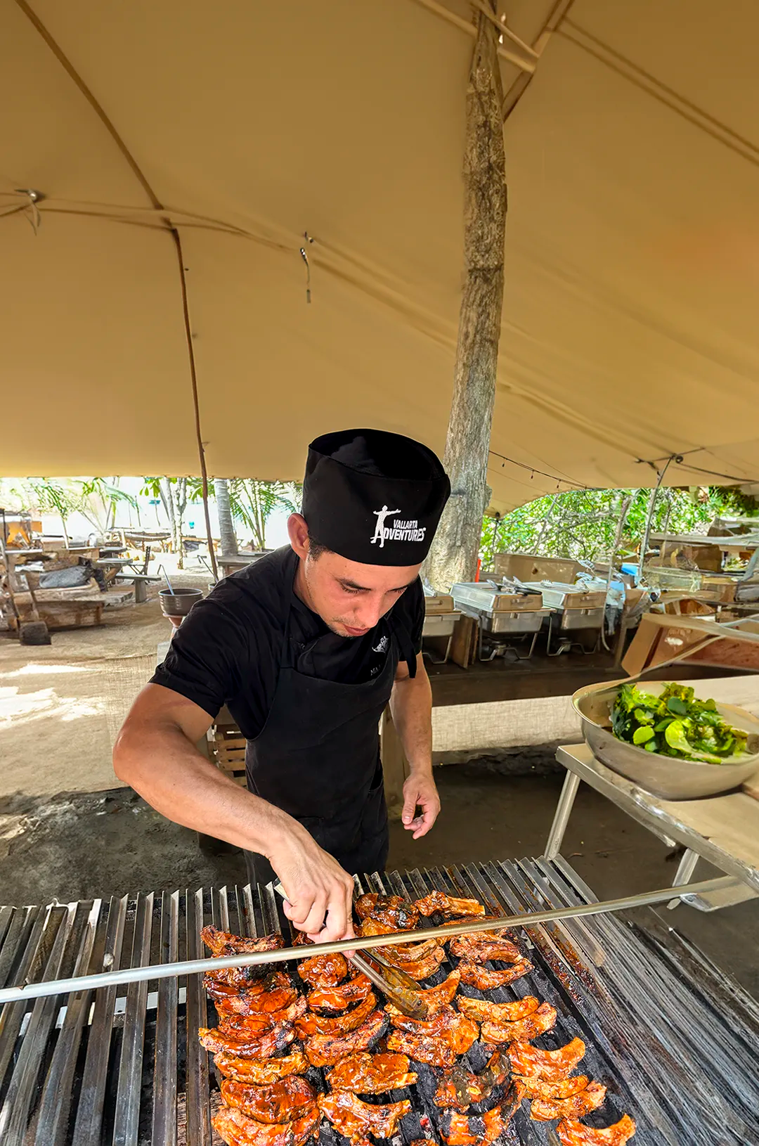 Cook grilling delicious BBQ ribs for a Vallarta Adventures tour.