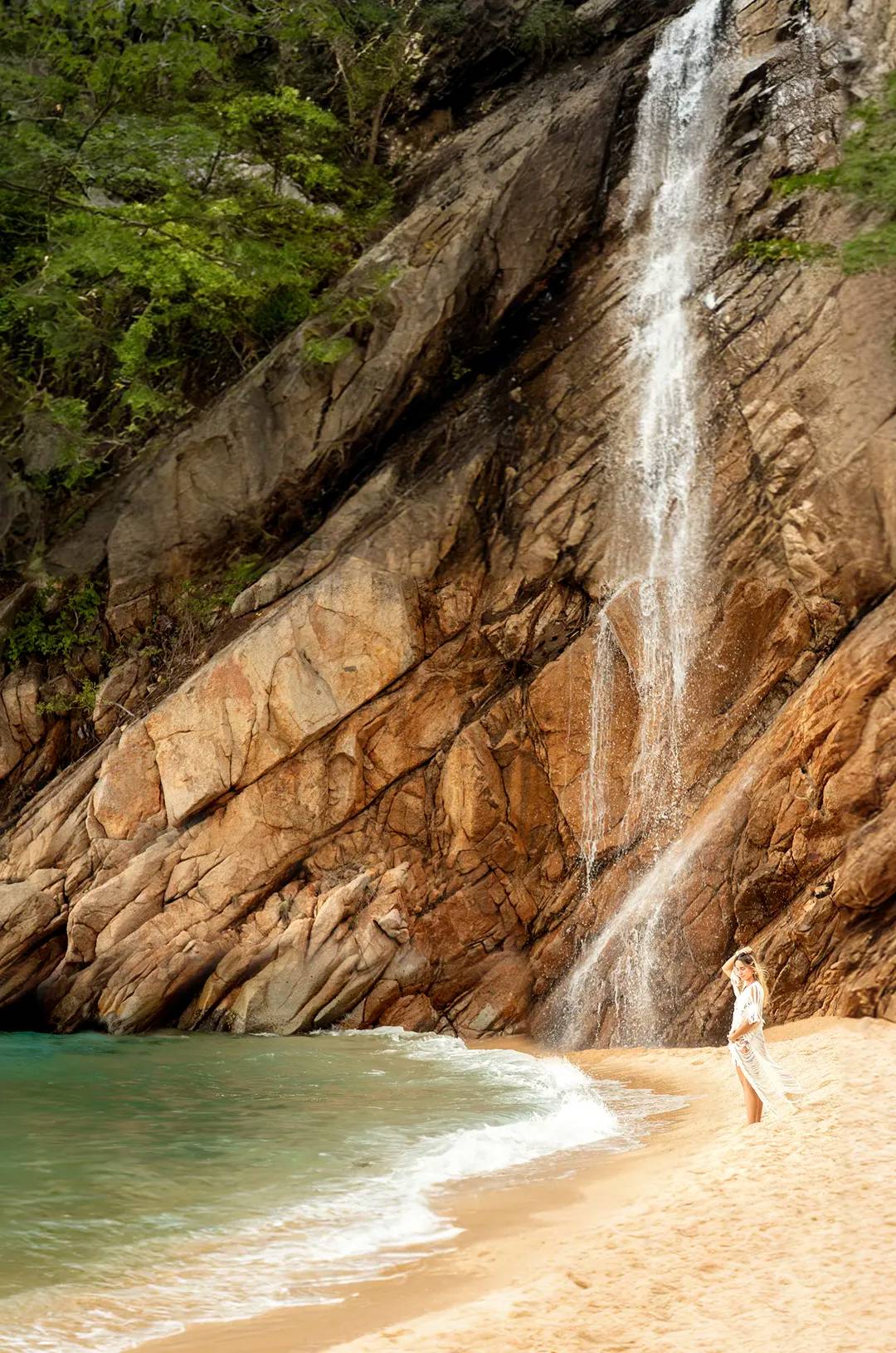 Woman stands by waterfall at Majahuitas Beach, Puerto Vallarta.