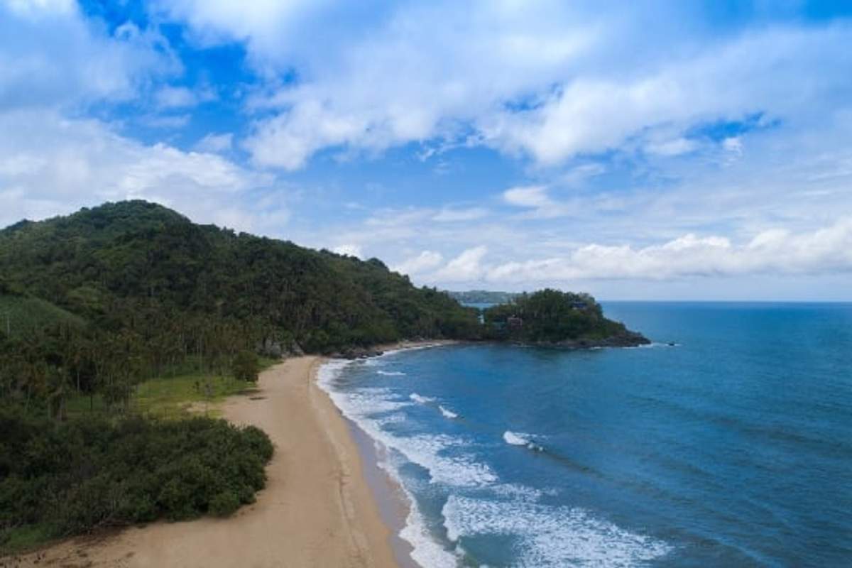 Vista aérea de la playa de San Pancho en Nayarit, México, con exuberante vegetación y olas suaves.