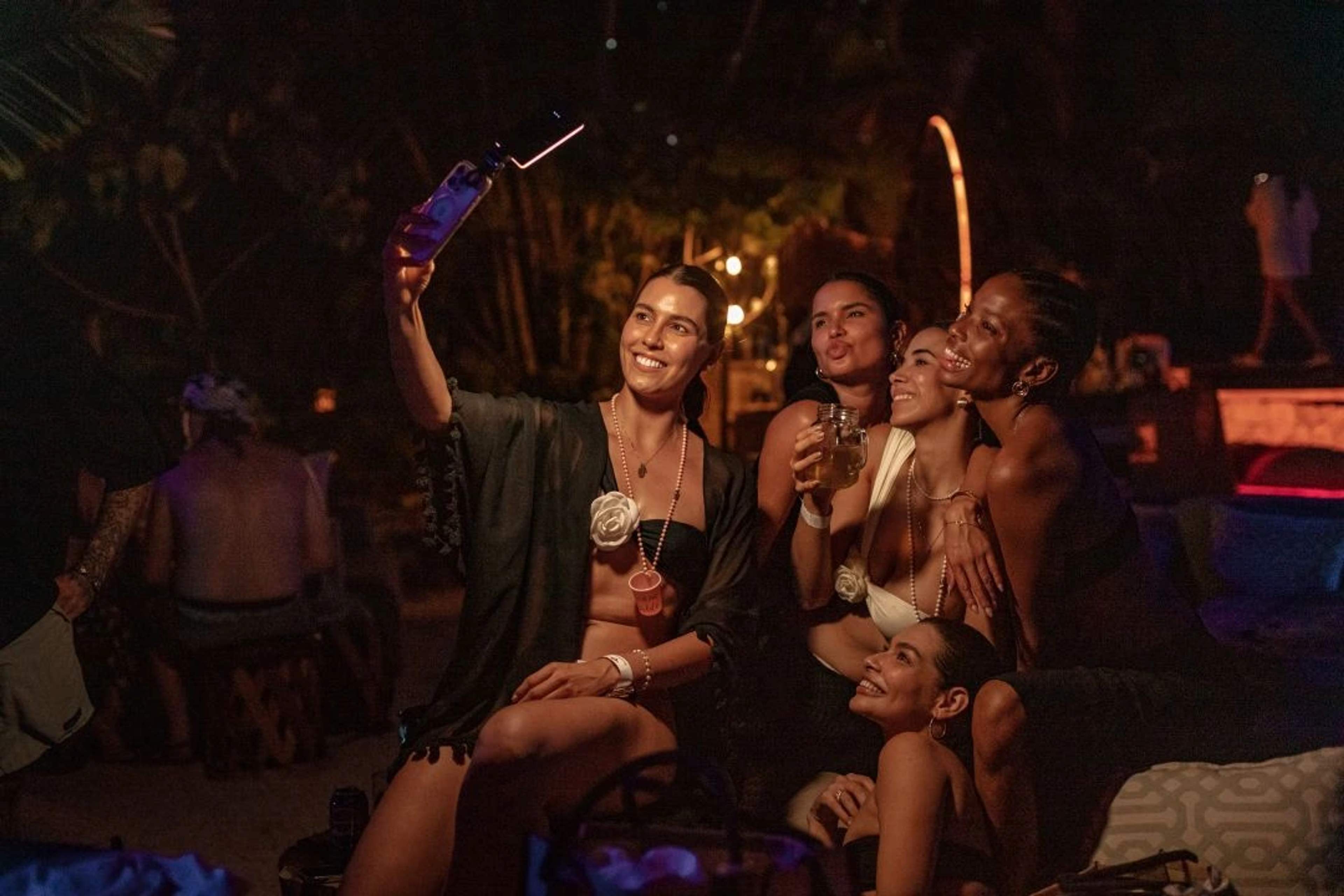 Two women taking pictures at a night party