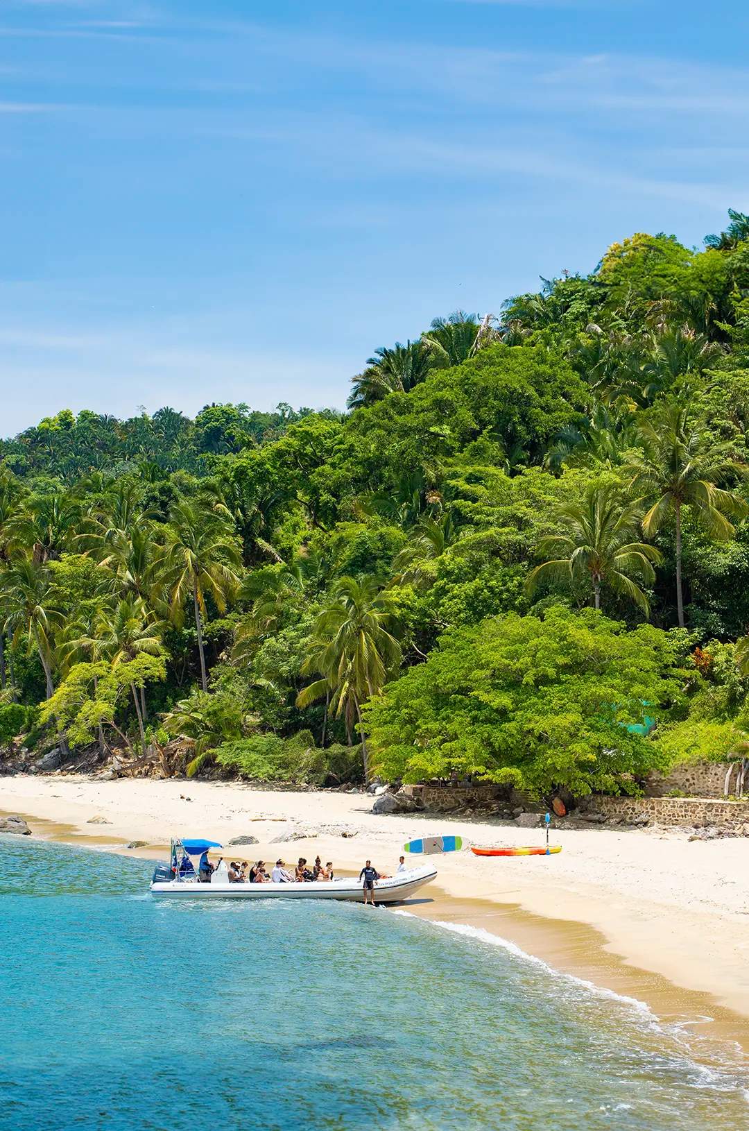 Playa aislada en Pizota con aguas turquesas claras y vegetación exuberante.