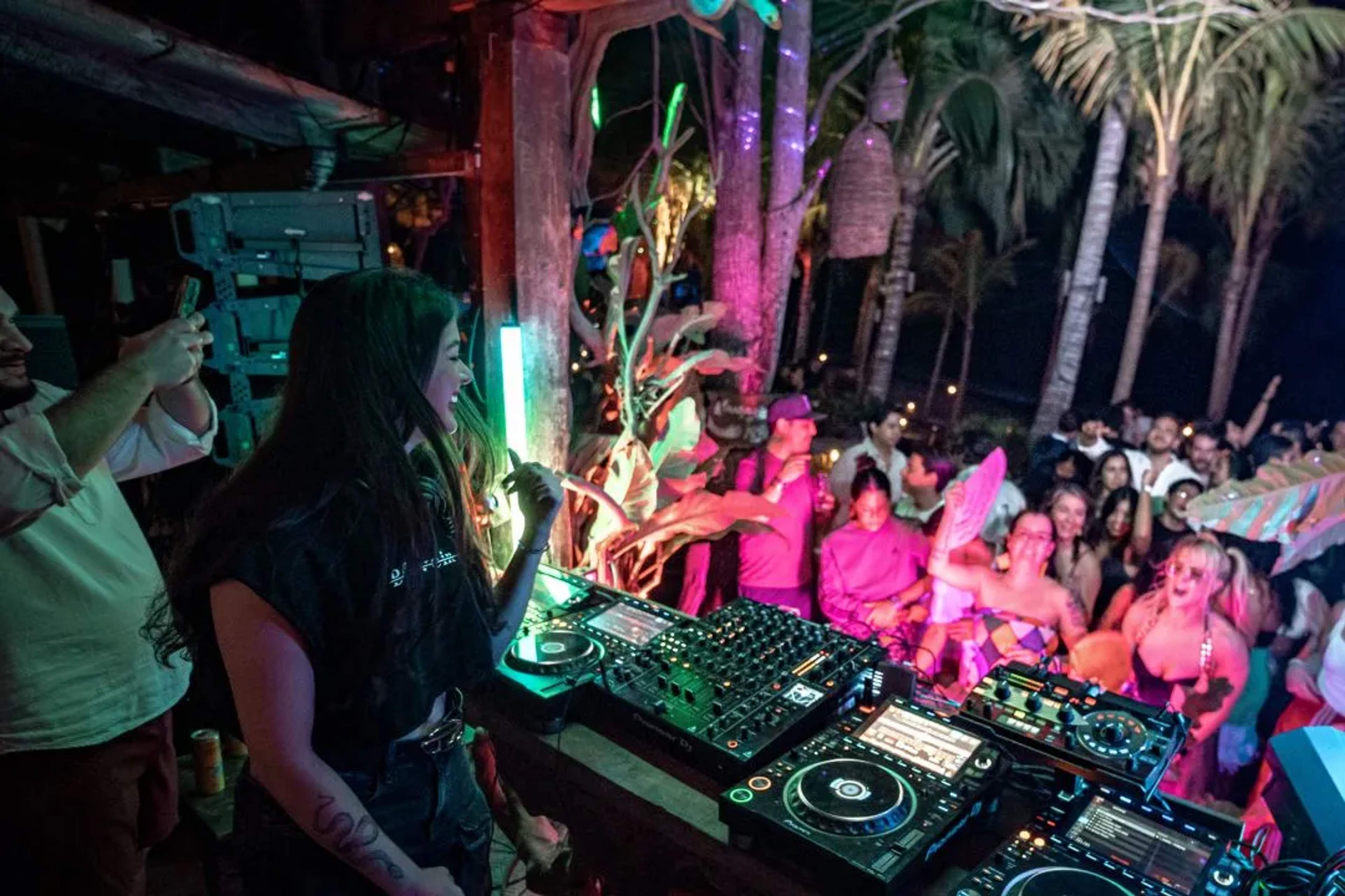 A DJ facing the crowd at a night event